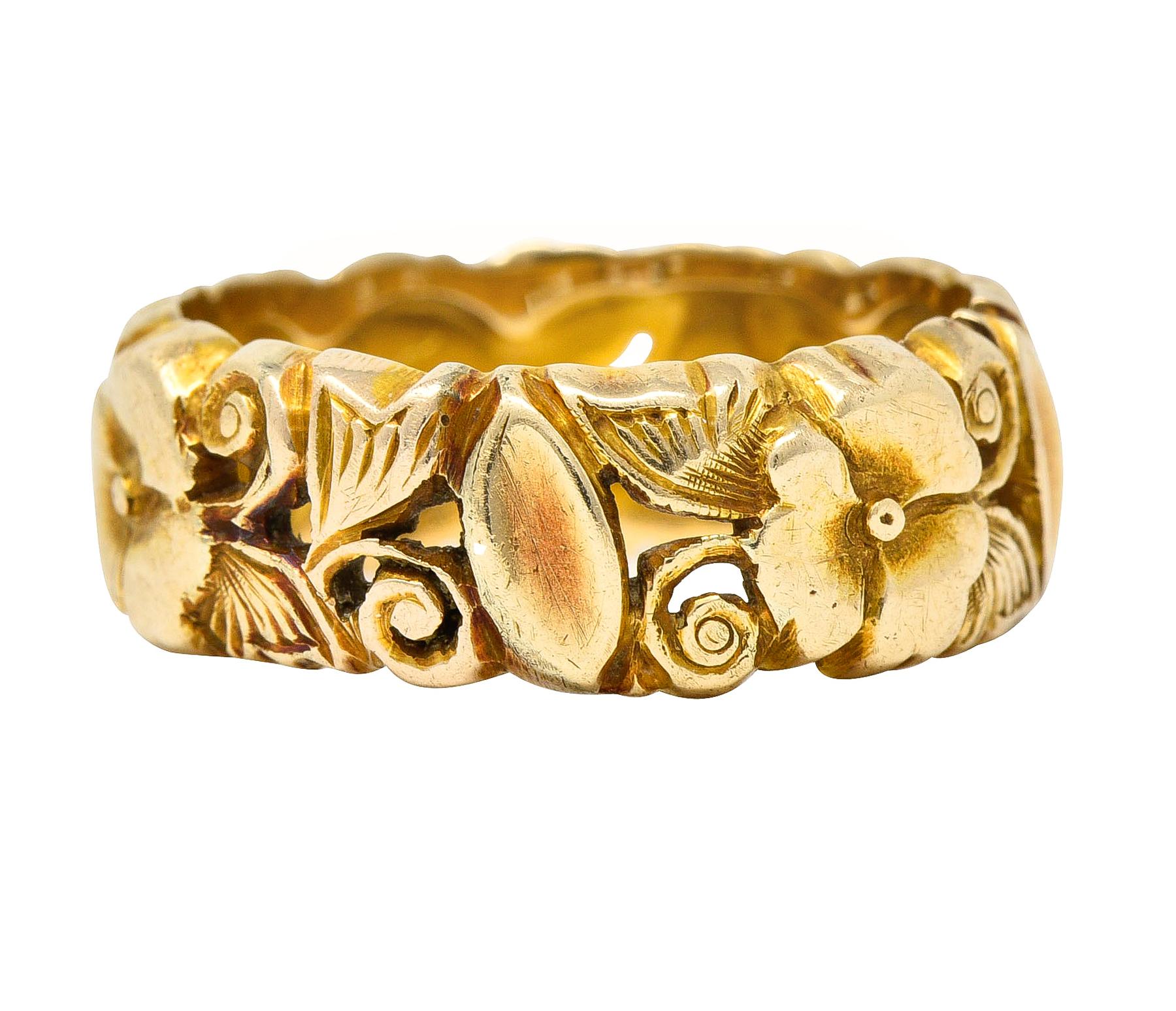 Designed as a highly rendered garland of pansy flowers fully around. Pierced with swirling vines and engraved foliage. Tested as 14 karat gold. Circa: 1905. Ring size: 7 1/4 and not sizable. Measures North to South 7.5 and sits 2.0 mm high. Total