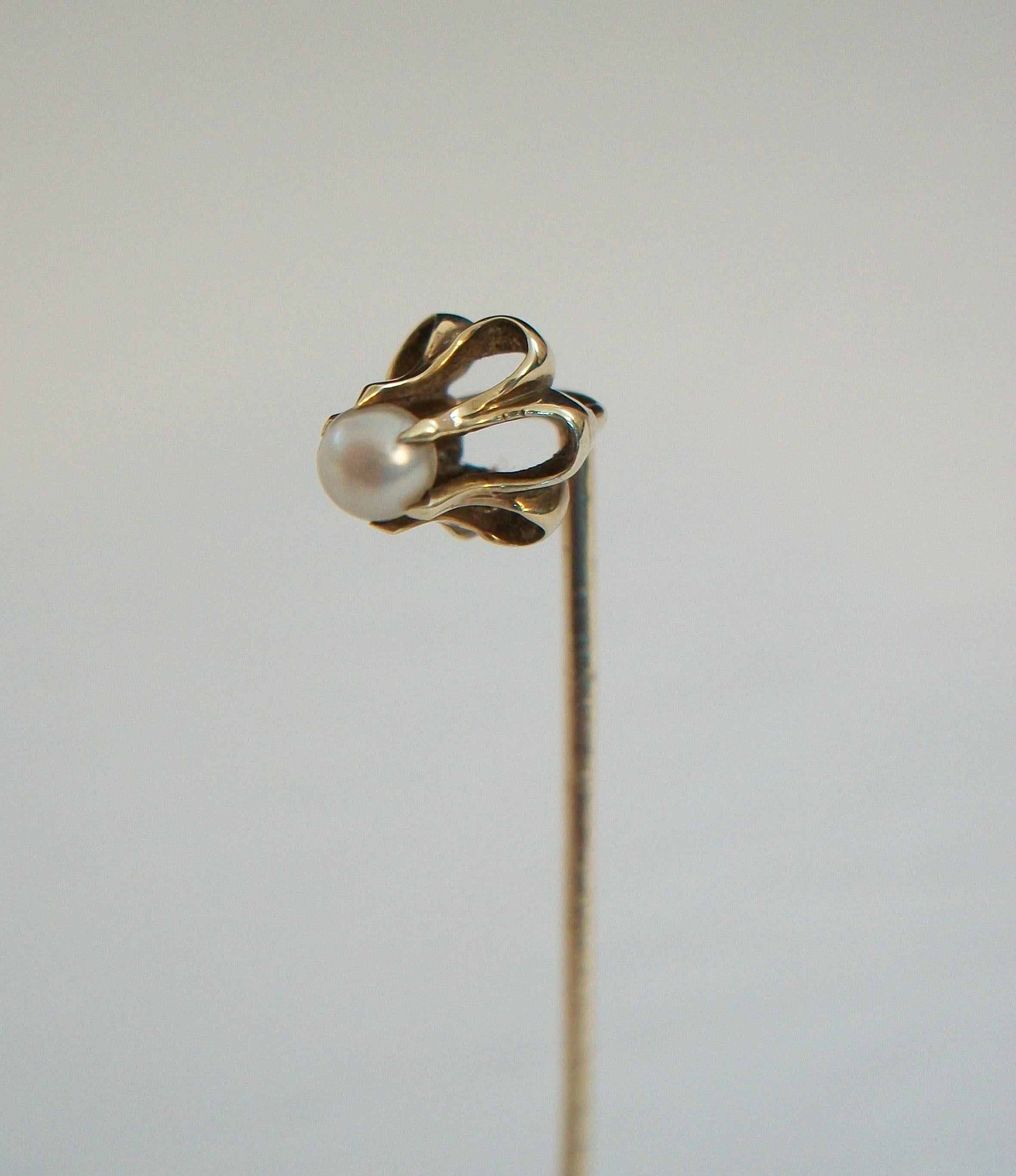 Art Nouveau 14K yellow gold and pearl stick pin - featuring a flowing stylized floral design set with a single pearl (3 mm. diameter) - hand made - stamped 14K on the pin - United States (likely) - circa 1910.

Excellent antique condition - all