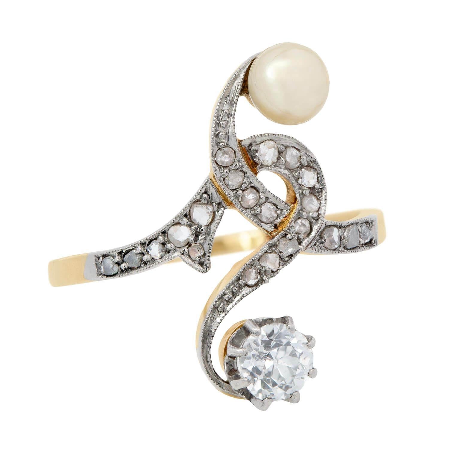A wonderful diamond bypass ring from the Art Nouveau (ca1890) era! Crafted in 14K yellow gold and platinum, this lovely piece features an old mine cut diamond and a pearl , which form a stylish 