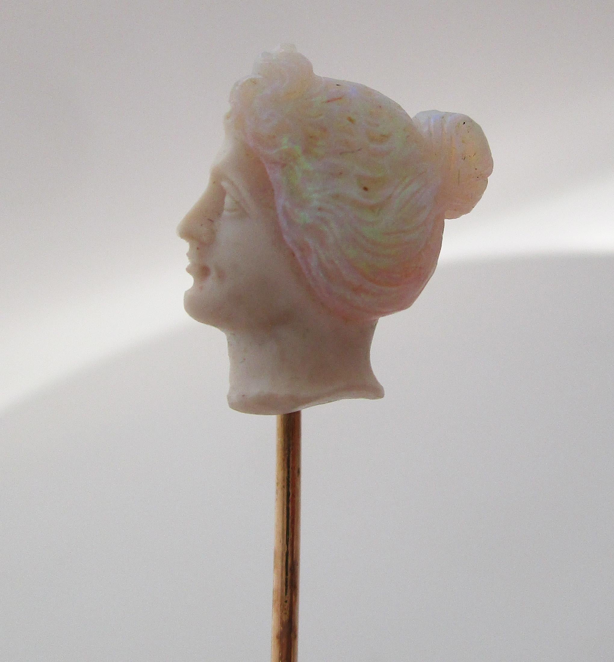 This is an ethereal Art Nouveau stick pin featuring 14k rose gold and a breathtaking carved opal bust! This pin is the epitome of Art Nouveau, with its combination of the enchanting color play of opal and the elegant look of a rose gold stick pin.