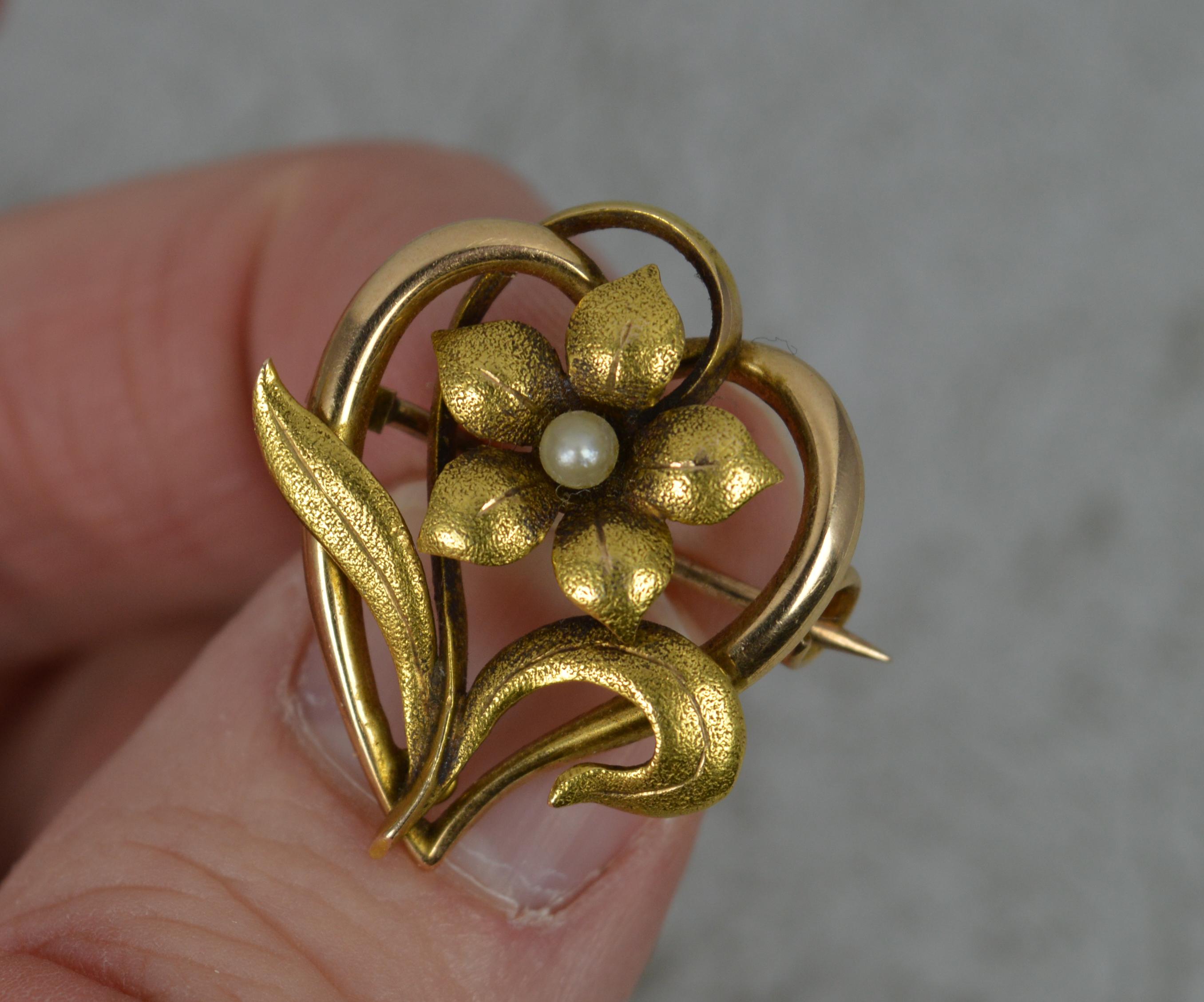A very fine art nouveau period brooch.
Solid 15 carat yellow gold example.
Floral or heart shape with forget me not flower to centre with pearl to middle of the head.

Condition ; Very good. Crisp pattern. Working pin and hinge. Clean pearl. Please