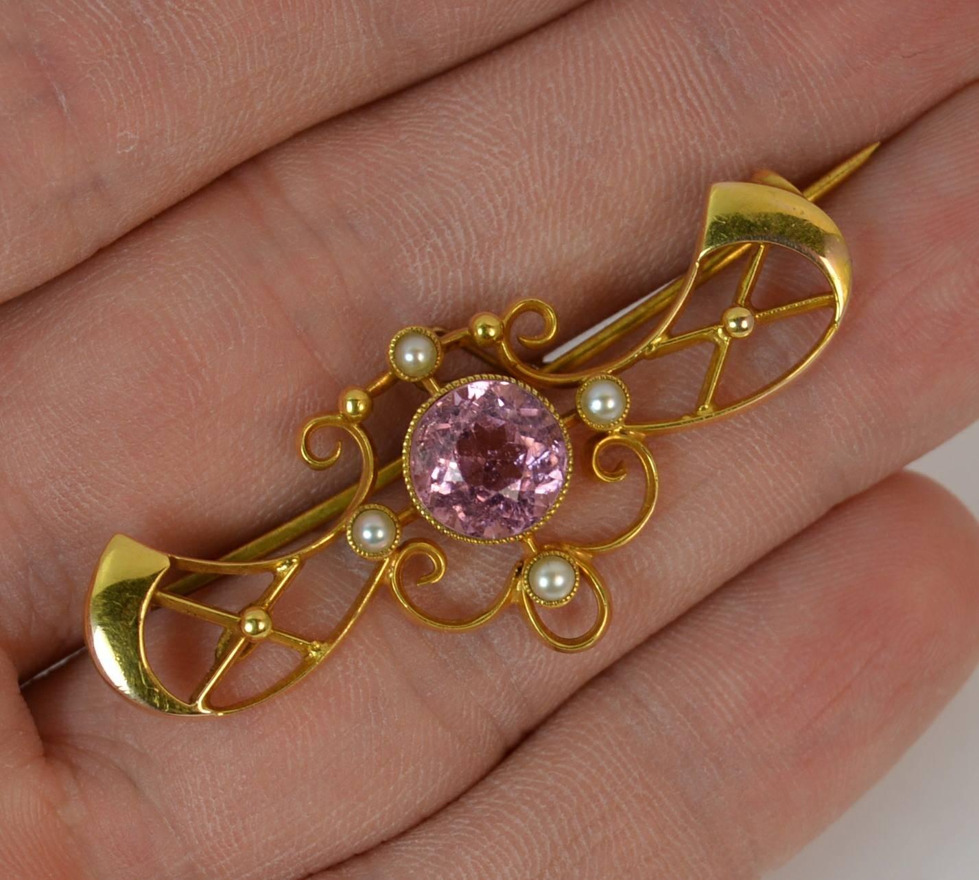 
A fantastic quality and highly desirable Art Nouveau period brooch. c1905.

Solid 15 carat yellow gold example.

​Set with a large natural round cut pink sapphire to centre, 8.5mm diameter in collet mount.

​The pierced design surrounding is set