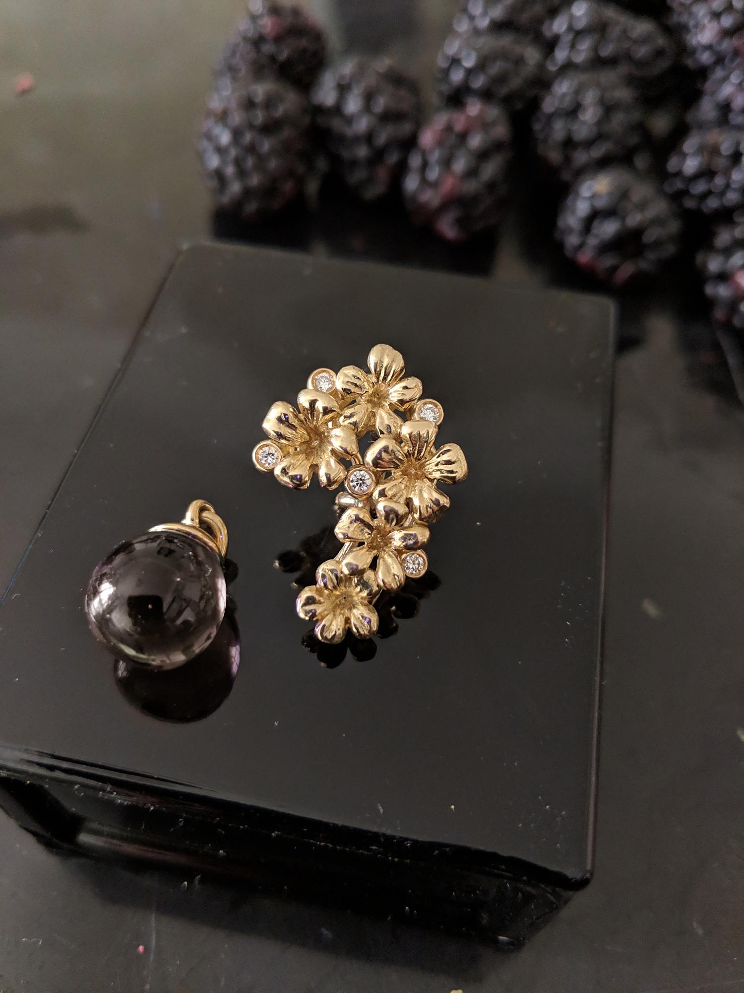This Plum Blossom Brooch is a unique sculptural piece made from 18 karat yellow gold, encrusted with 5 round diamonds and a removable cabochon smoky quartz drop. We use top natural diamonds, VS clarity and F-G color, and work with a German gems