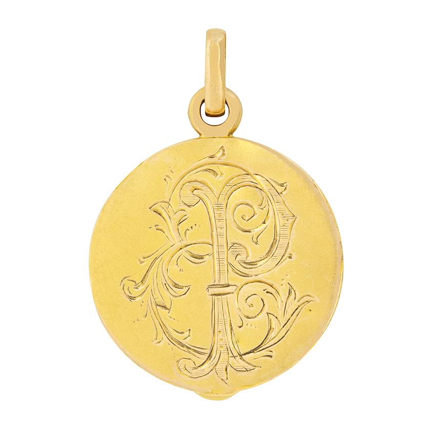 A graceful depiction of a lady adorns this Art Nouveau locket. Her profile is expertly carved into the 18 carat yellow gold, and is surrounded by sinuous leaves and vines. This locket opens, and is fitted to be a pendant.  
Metal: 18ct Yellow