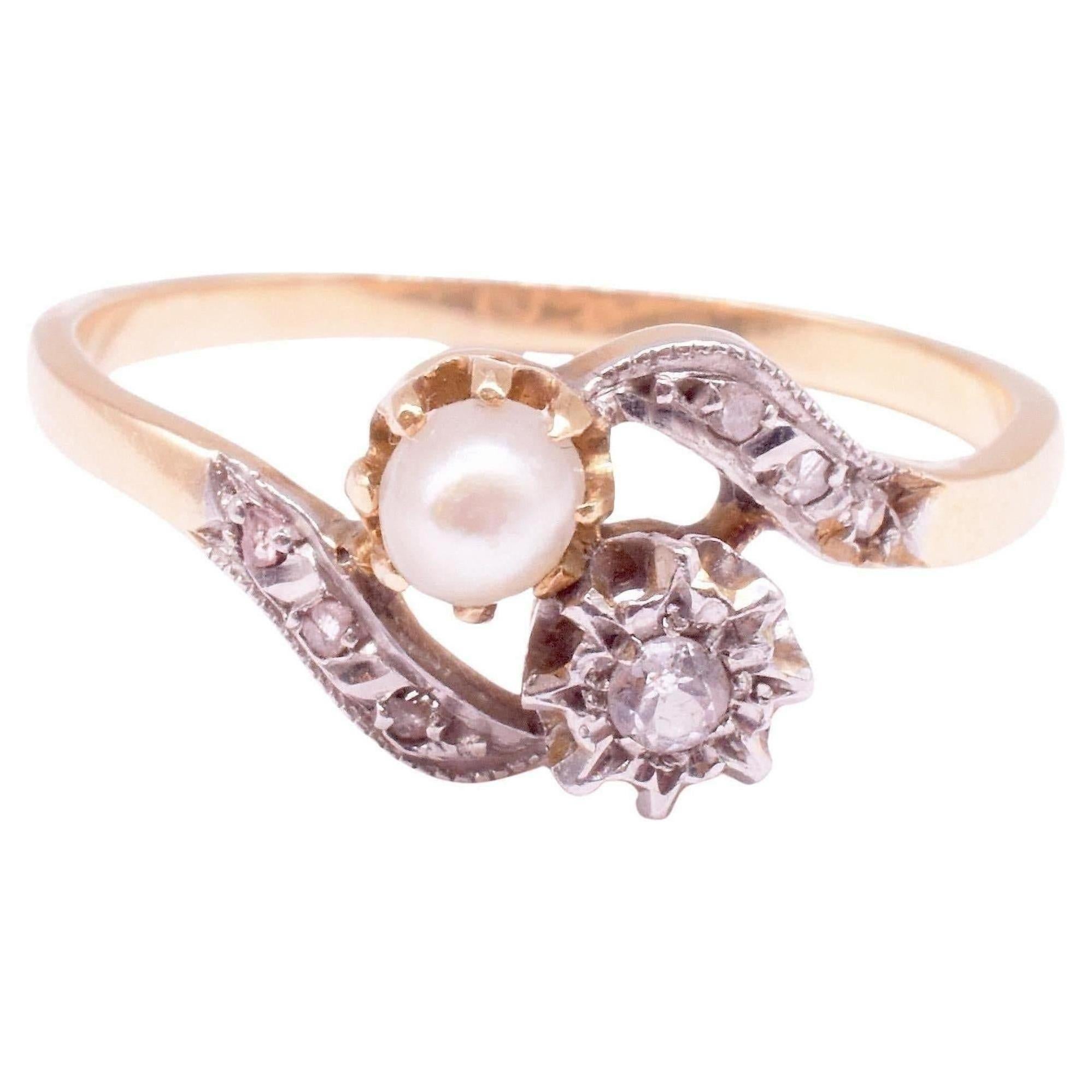 How can you not love this French Art Nouveau  Flower Sprig Crossover Ring set with a .15 carat cushion cut diamond and a natural pearl plus six small rose diamonds in the stem. The ring tests 18ct gold with a platinum top and was made circa