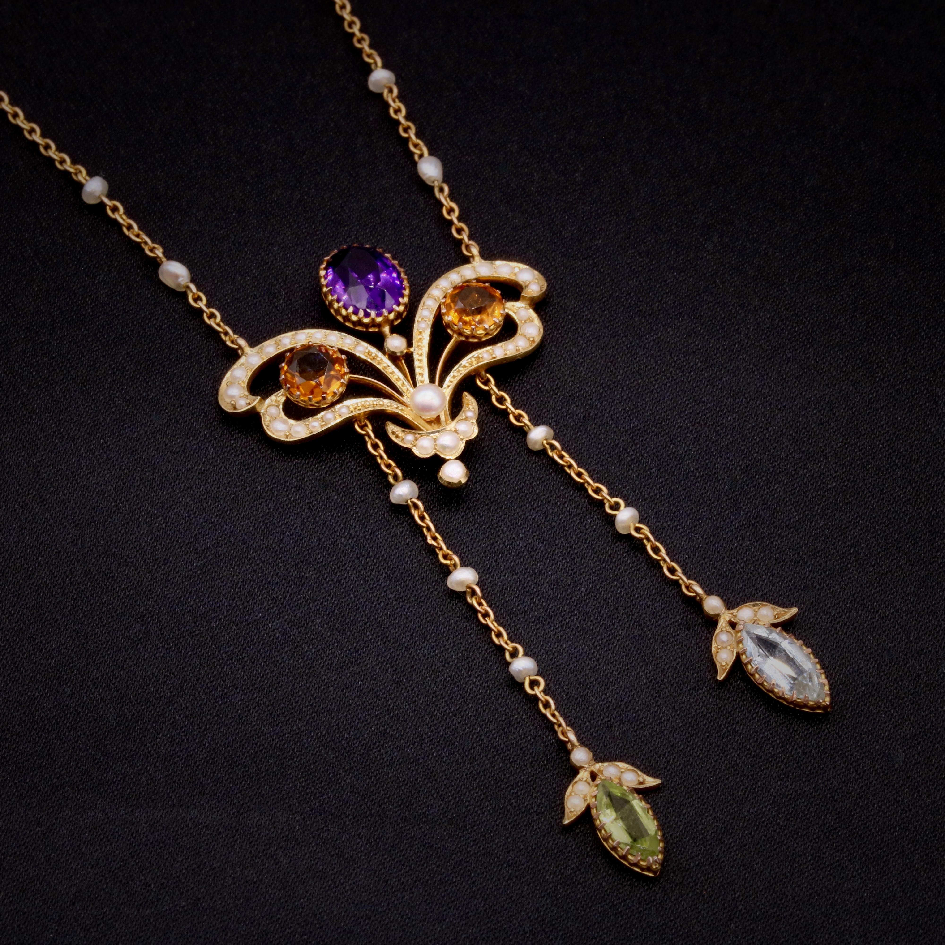 An Art Nouveau amethyst, citrine, aquamarine, peridot, pearl, and yellow gold necklace, comprising one oval cut amethyst, two round cut citrines, one marquise cut aquamarine, one marquise cut peridot, and sixty-one seed pearls, set in 18 karat