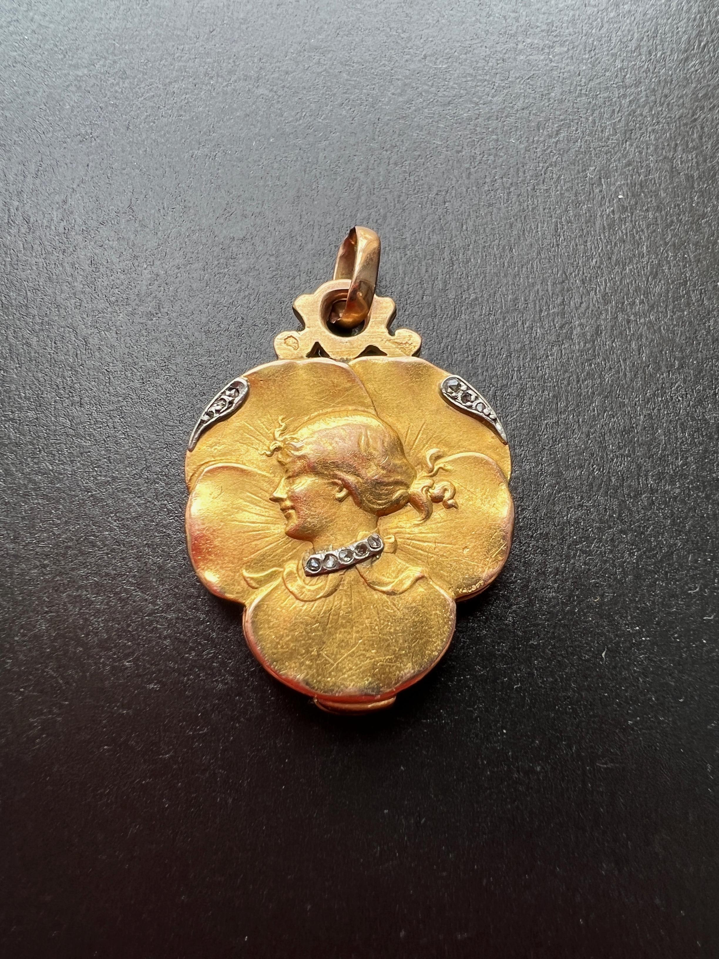 Flowing lines and curves marked the Art Nouveau style, with women and nature as its primary subjects.

For sale a very rare French Art Nouveau era 18K gold pendant, featuring a lady on a pansy flower. The pendant has a slid clasp on its bottom,