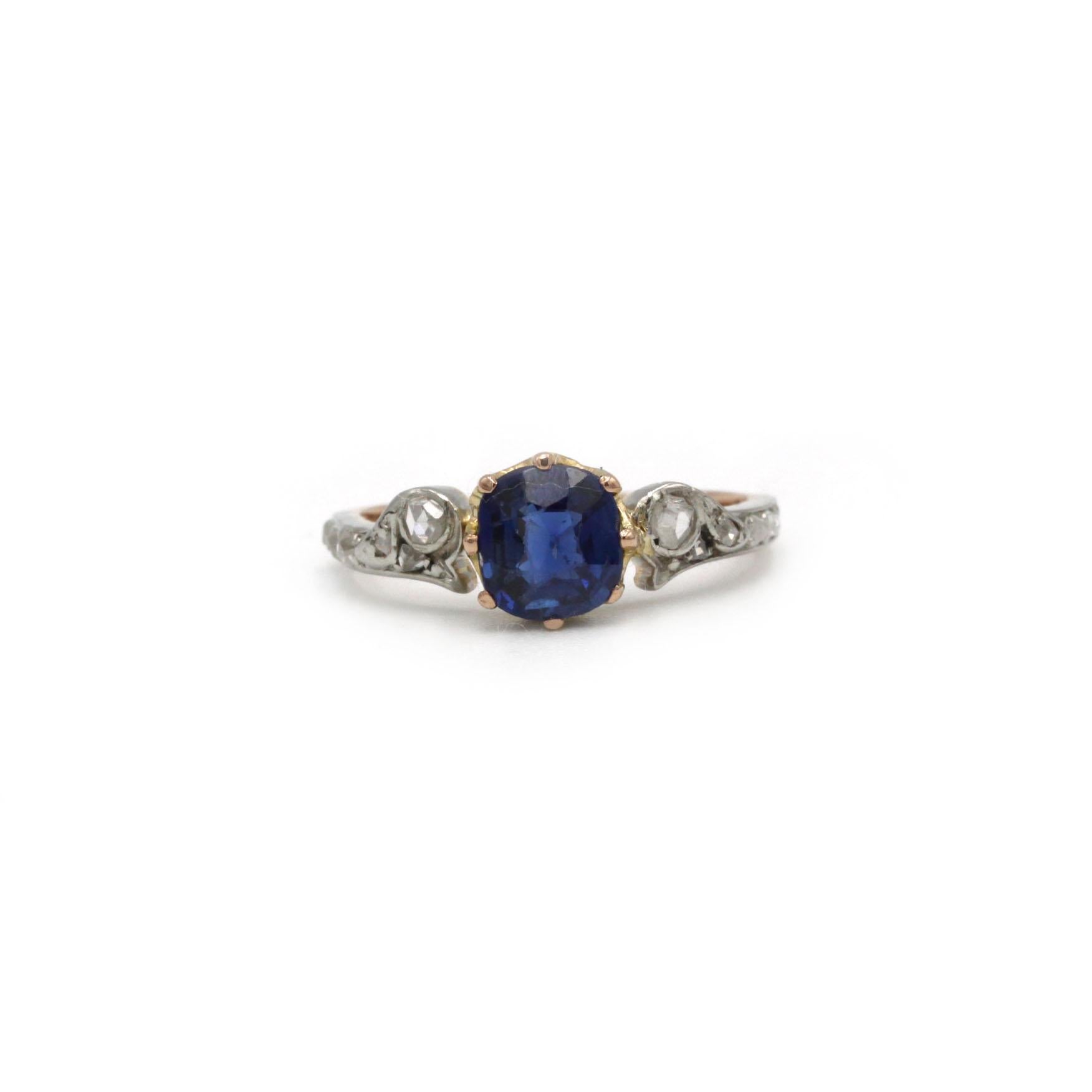 Délicate bague Art Nouveau en or 18 carats, ornée d'un saphir bleu vif d'environ 1,0 carat. La pierre est maintenue dans une monture basse de type couronne et est flanquée sur chaque épaule d'une ligne de petits diamants taillés en rose et sertis
