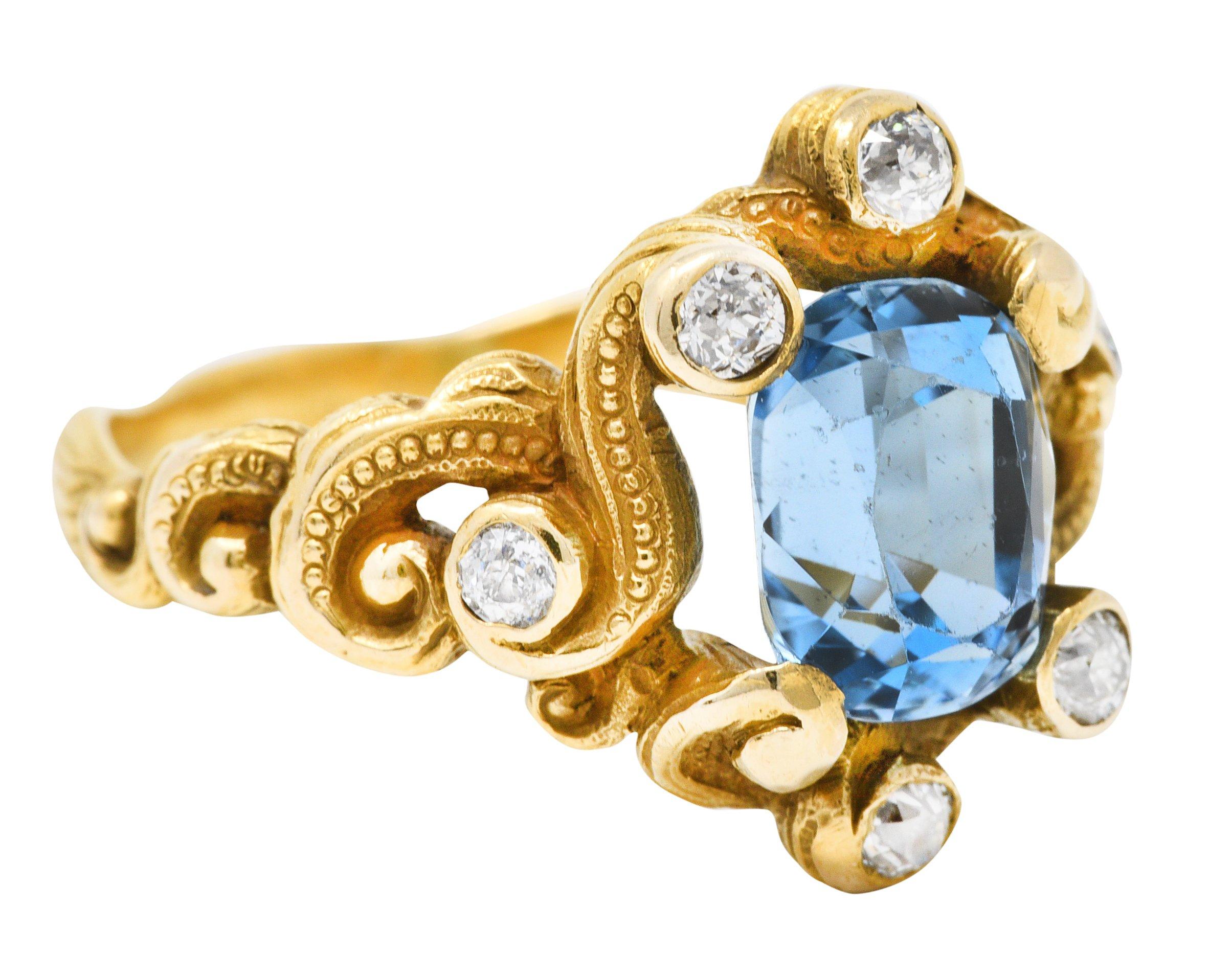 Band ring is designed as scrolling whiplash tendrils accented by gold bead detail

Centering a rectangular cushion cut aquamarine weighing approximately 1.70 carat

Transparent with strong and uniform sky blue color

With old mine and old European