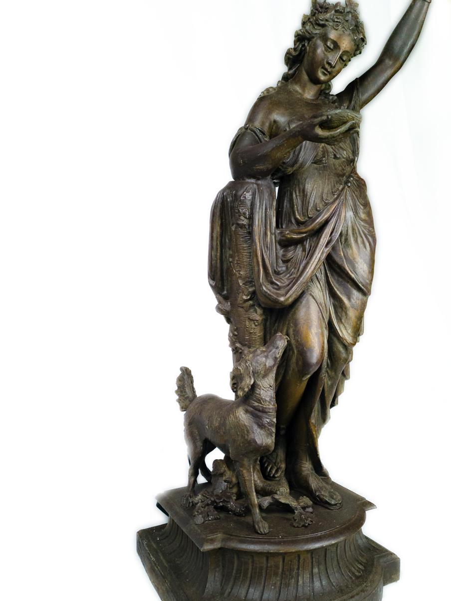 A large Belle Epoque 19th century french spelter sculpture statue lam of a woman holding a illuminated  yellow tulip shaped glass.