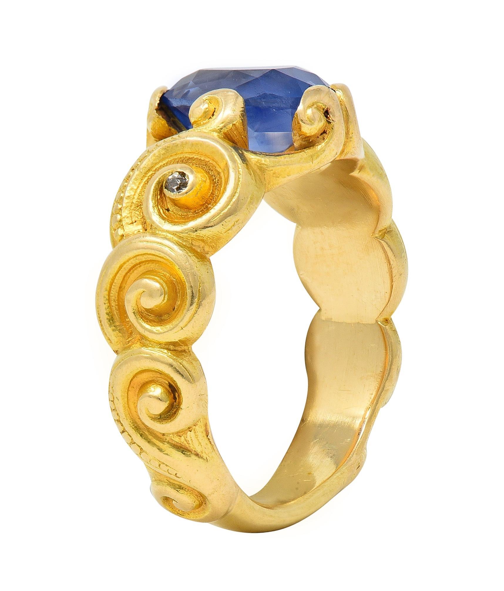 Centering an oval cut sapphire weighing approximately 2.23 carats - transparent light to medium blue 
Set with highly rendered swirl motif prongs with pierced surround 
Flanked by deeply carved swirling shoulders with beading detail
Accented by