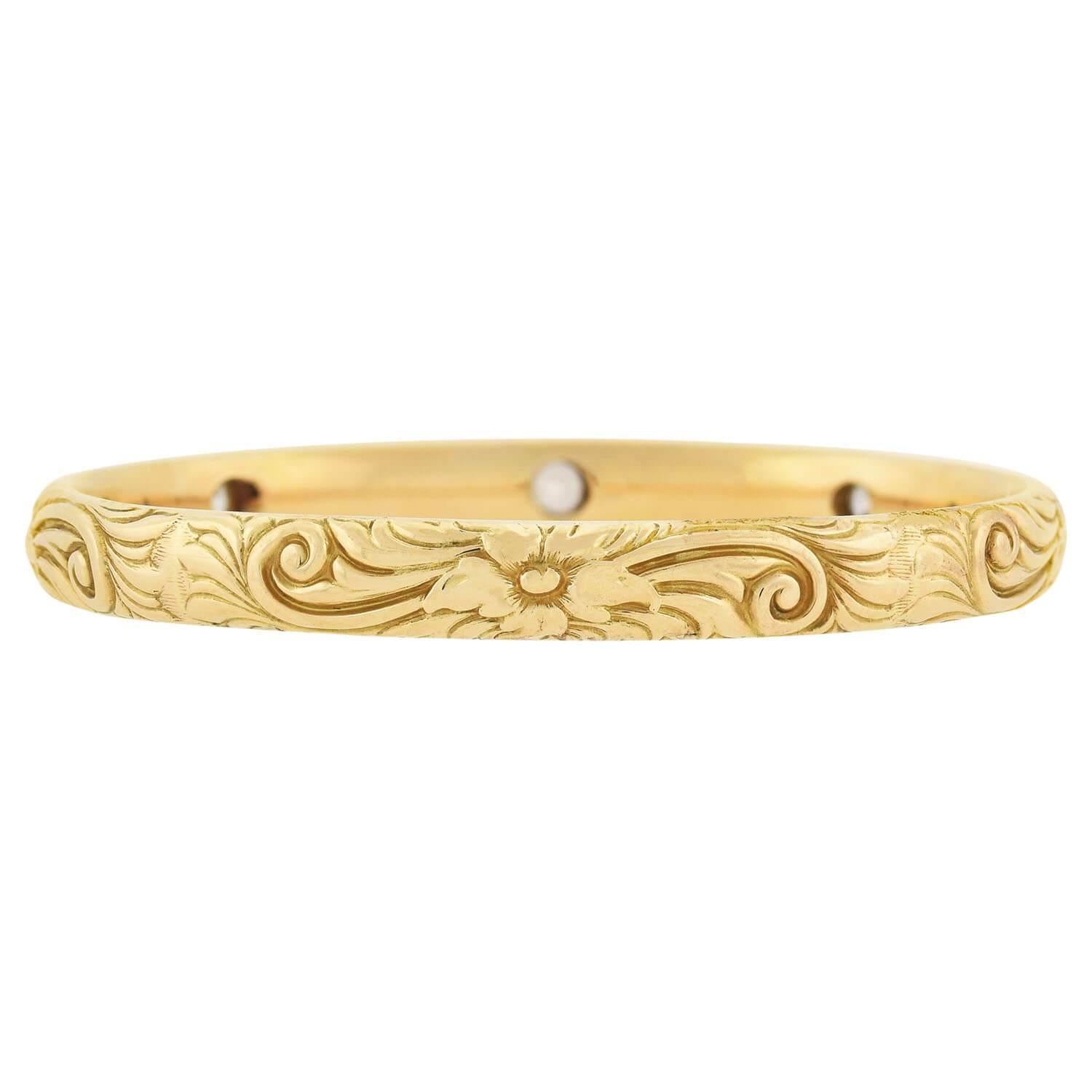 An exquisite bangle bracelet from the Art Nouveau (ca1909) era! This slip-on style bangle is crafted in 14kt gold and features a lovely repousse motif. The flowing design covers the entire surface of the bracelet, creating a graceful pattern of