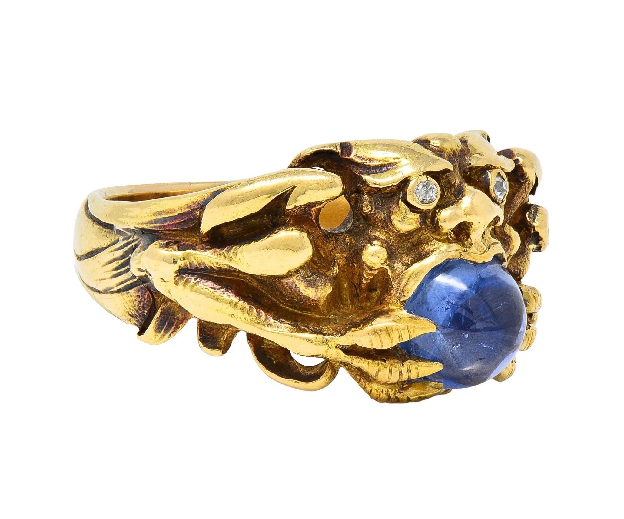 Designed as a stylized gargoyle with garish features, spread wings, and pointed claws
Clutching a domed sapphire cabochon weighing approximately 2.35 carat total
Transparent medium-light blue in color - prong set with claws
Accented by old single