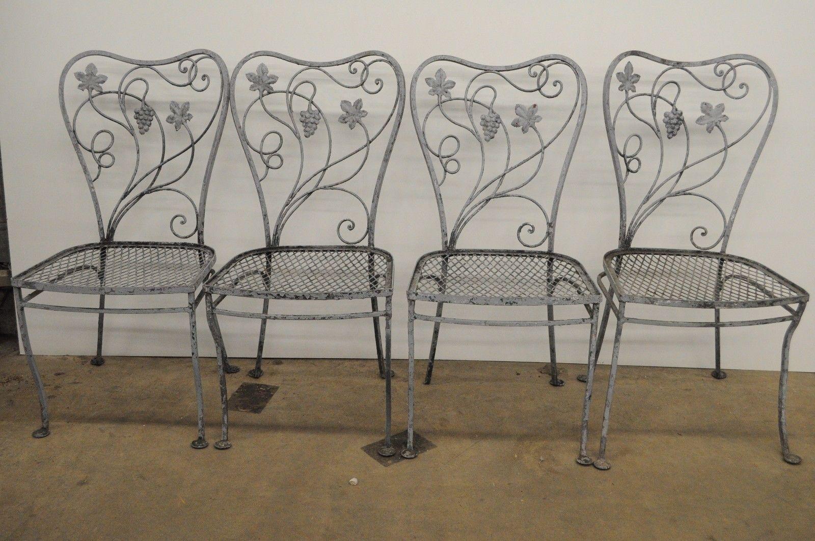 Vintage Mid Century / Art Nouveau 5 Piece Wrought Iron Patio Dining Set believed to be John Salterini. Great quality vintage set for refinishing. Item features round table with umbrella holes, 4 dining side chairs, floral scroll work, grape and leaf