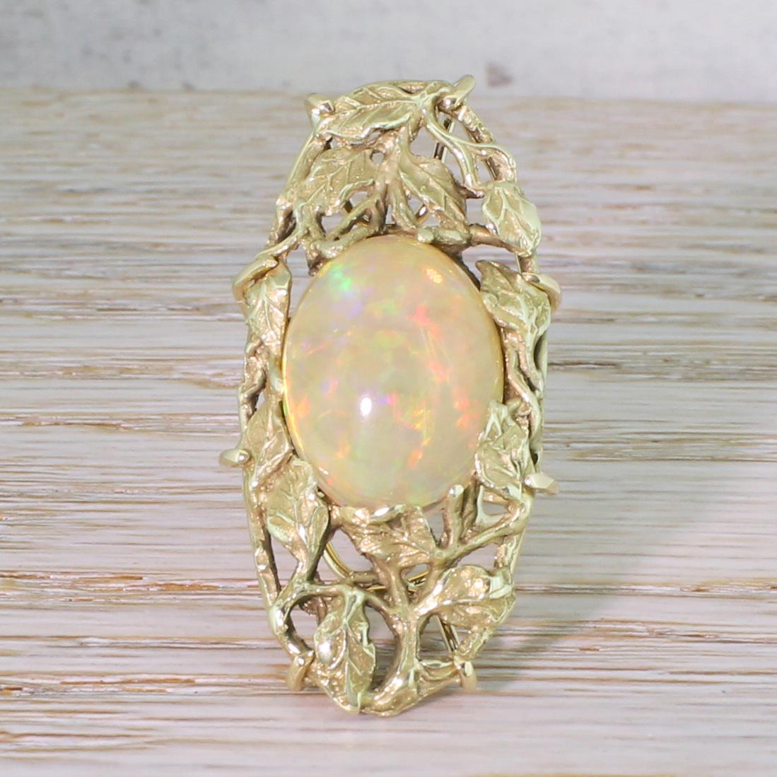 An awesome Art Nouveau ring. The glowing opal in the centre shows an impressive play of colour. The stone sits at the centre of a wonderfully crafted setting, with stunningly intricate foliate detailing. The top of the ring appears to have started