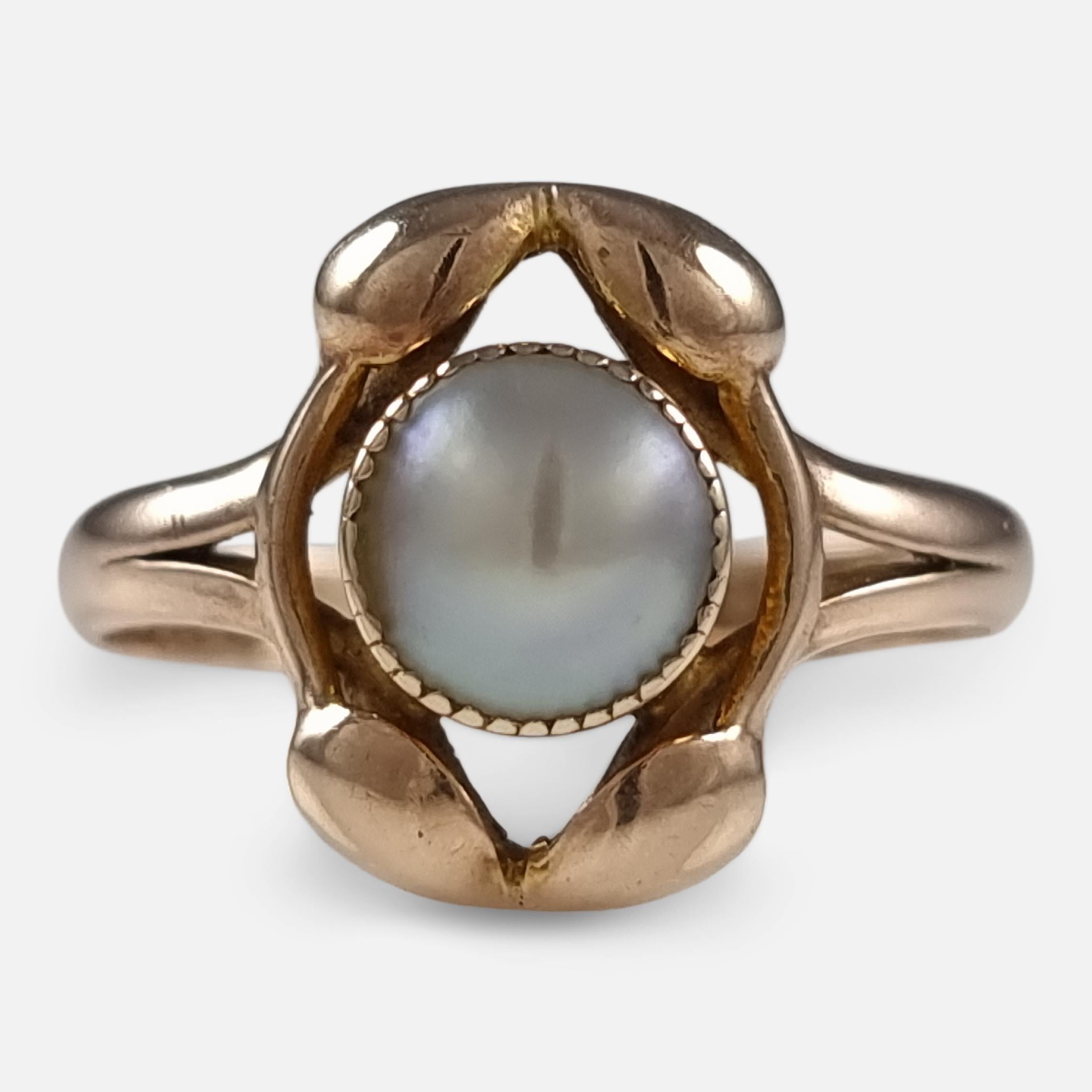 An Art Nouveau 9ct mellow rose gold pearl ring. The ring is set with a central mabe pearl, within an open-work surround of vine tendrils in the Art Nouveau style.

The ring is hallmarked with Chester assay marks, 1911; '9.375' to denote 9 carat