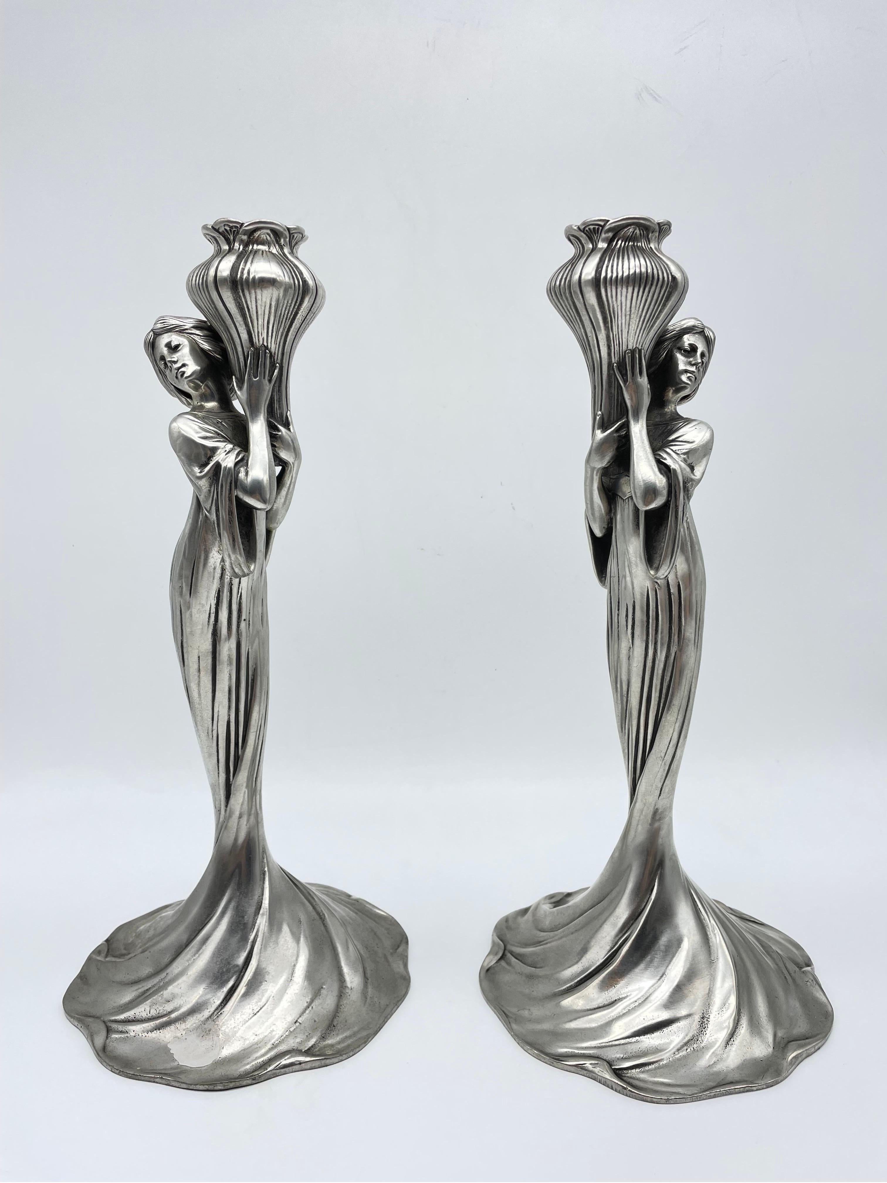 Ein Paar Achille Gamba (Italiener, 1881 - 1941) für Edles Zinn (Zinn) Jugendstil-Kerzenhalter aus deutschem Zinn mit einem figuralen Design, das Frauen mit Blütenstempeln darstellt. Alle sind an den Unterseiten vollständig gestempelt.