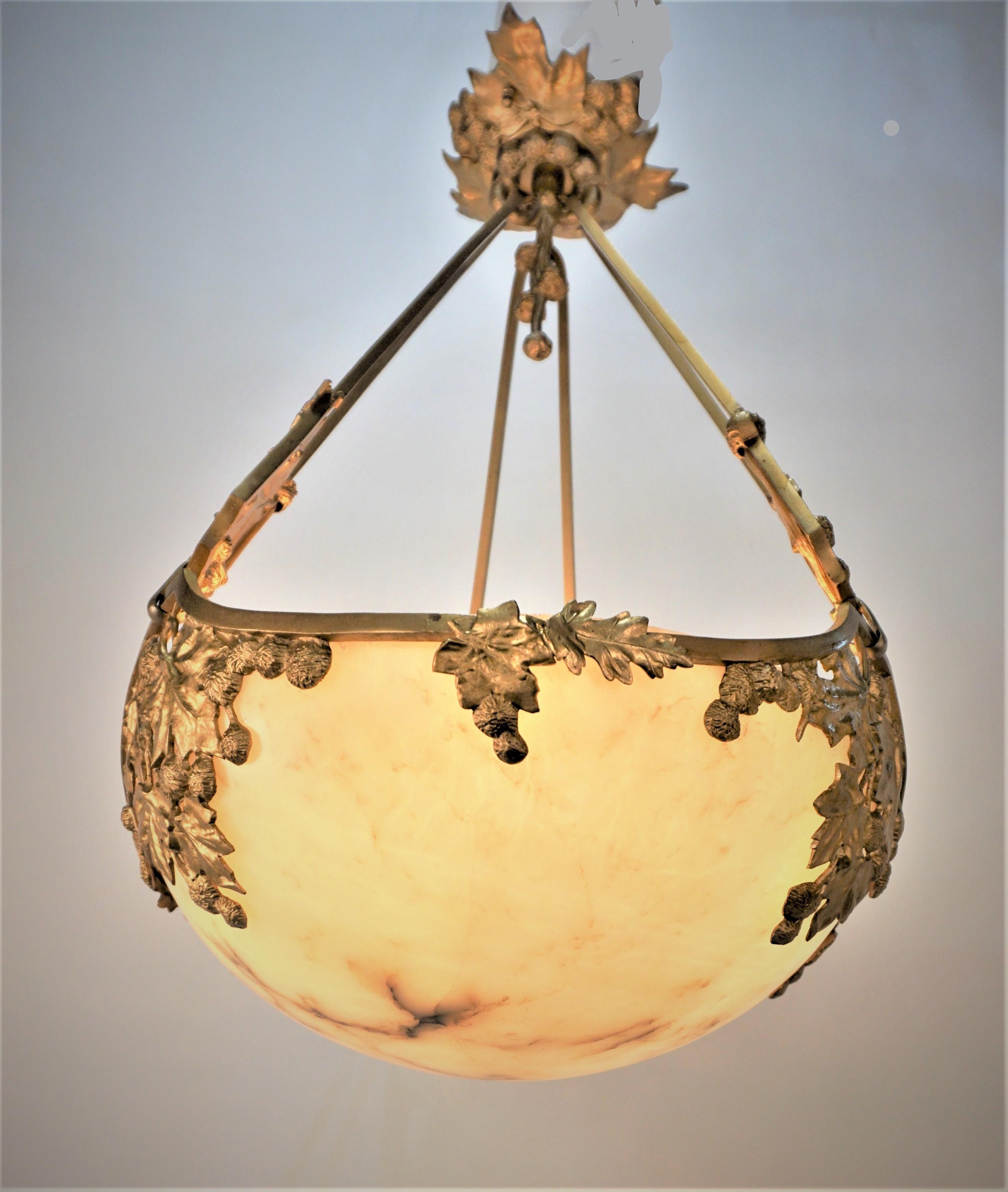 Early 20th century gilt bronze with center alabaster chandelier.
Six lights, 75watts max each.