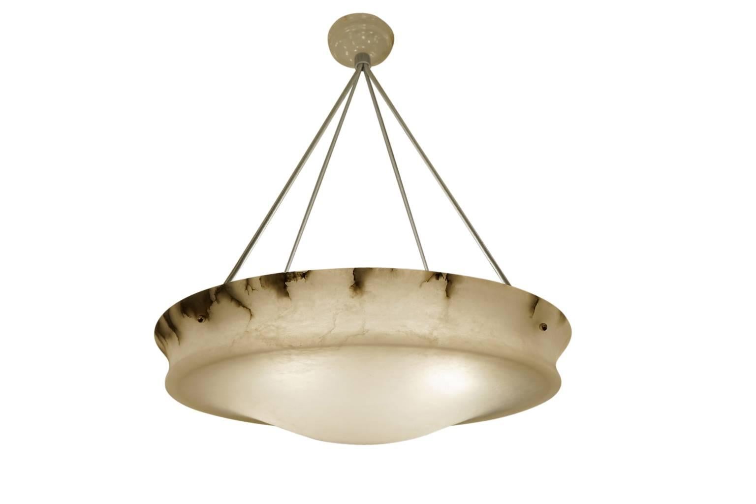 This dramatic fixture features clear white alabaster 