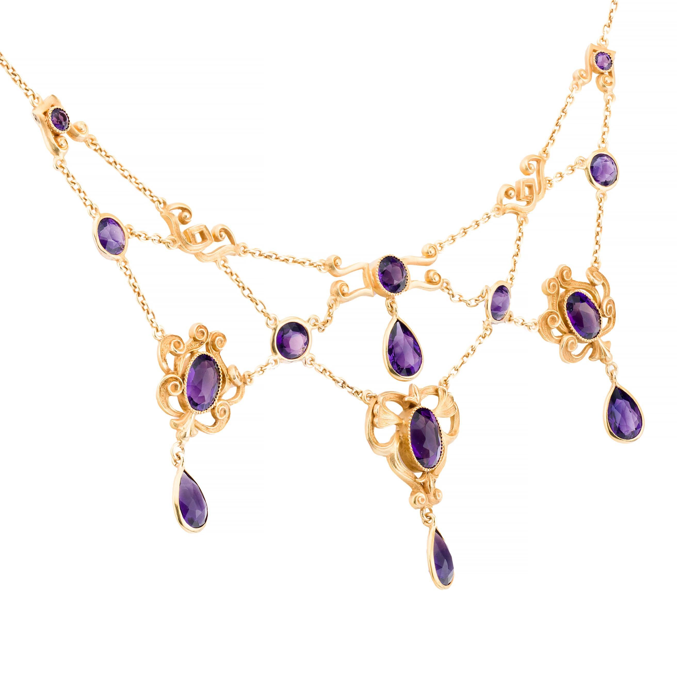 Aston Estate Jewelry Presents:

An exquisite Art Nouveau bib necklace from 1900, crafted in 14k yellow gold. This remarkable piece showcases a series of mixed-cut amethysts, totaling 16.8- carats, in a rich purple hue. The intricate design features