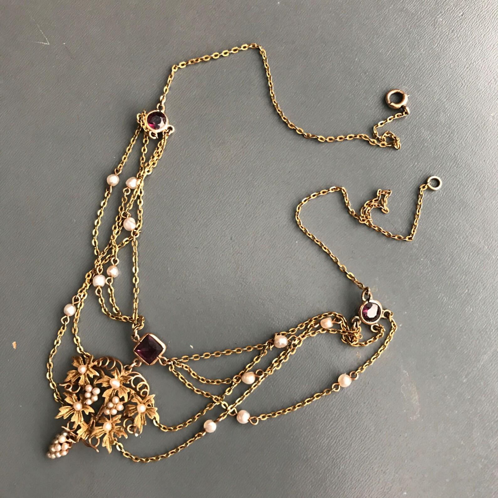 Arte Antiques OF PEARLS collier swag avec or 10kt et perles de rocaille authentiques .
Le pendentif central présente une grappe de raisin en or et en perles de rocaille entourée de feuilles d'or. Le collier se termine par un fermoir à ressort
