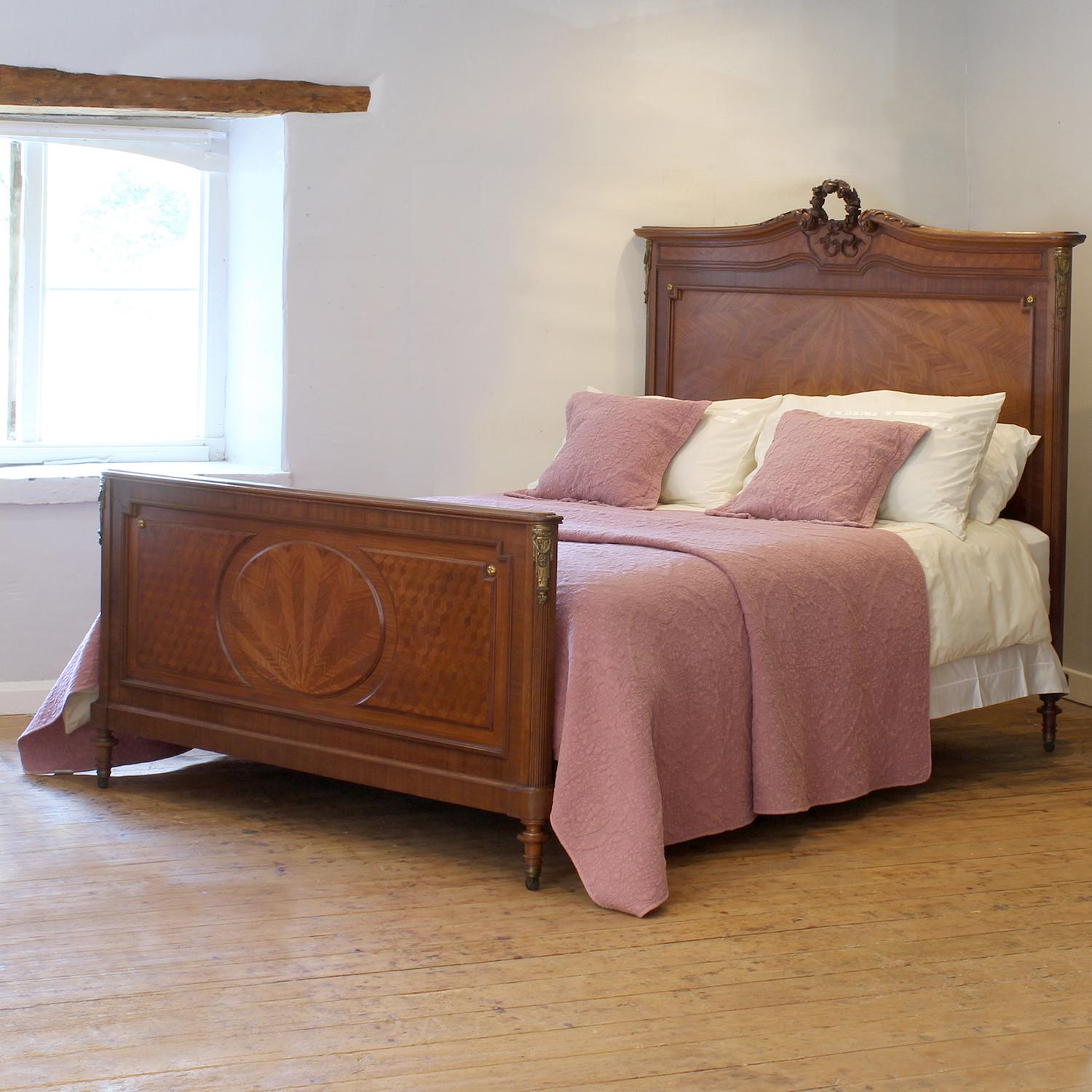 Ein attraktives antikes französisches Bett im Art-Déco-Stil mit Sonnenschliff- und Parkettintarsien, geschnitztem Girlandengiebel und Ormoludekor.

Dieses Bett ist für ein US-Queen-Size-Bett (oder ein UK-King-Size-Bett) mit einer Breite von 60 Fuß