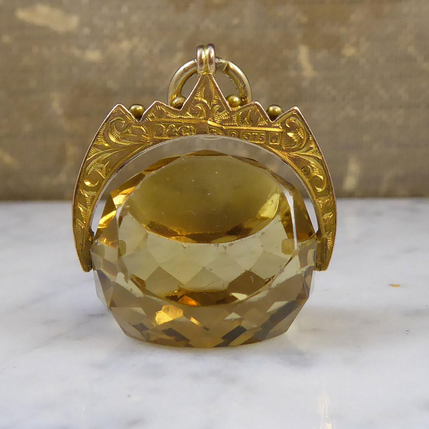 A lovely Art Nouveau antique spinner fob comprising a faceted citrine cut with three plain edges in an overall triangular shape.  The citrine displays a soft brownish, yellow colour and spins through a gothic style, yellow gold bracket which is