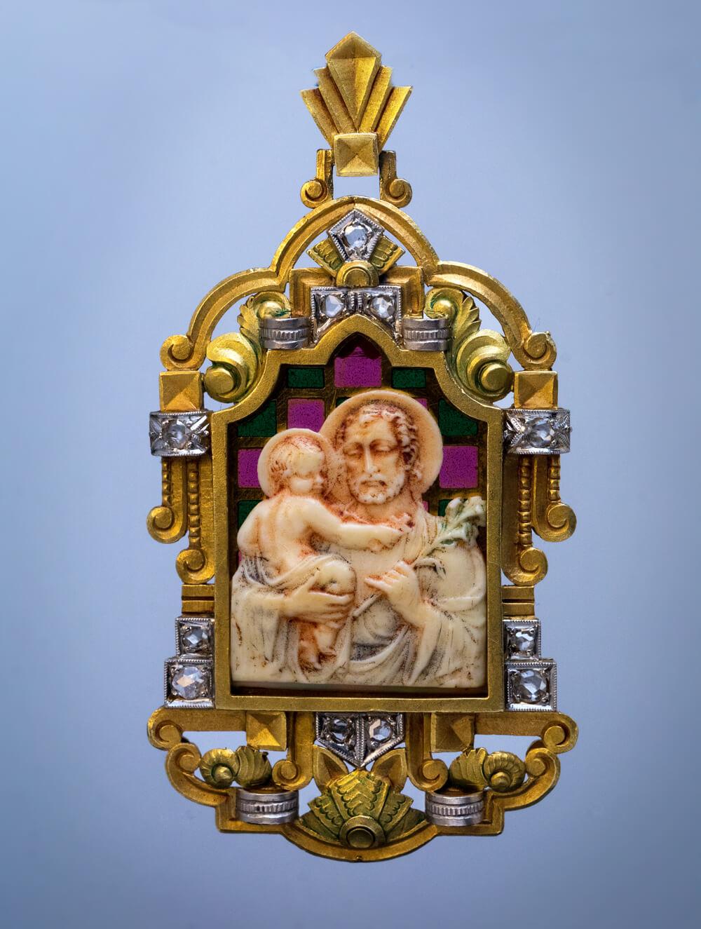 Spain, circa 1910

This Art Nouveau antique pendant features a finely carved bone relief of Saint Joseph holding baby Jesus. The relief is laid on a plique-à-jour enamel plaque and set in an elaborate two-tone matte gold, platinum and rose cut