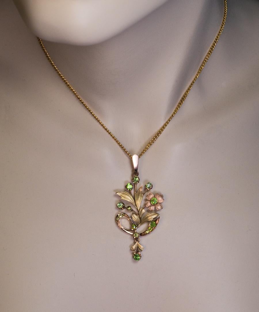 Made in Moscow between 1899 and 1908.

This elegant Art Nouveau era rose and green 14K gold pendant is designed as a stylized flower accented with Russian demantoid garnets.

The pendant is marked on frame with 56 zolontik Russian Imperial gold
