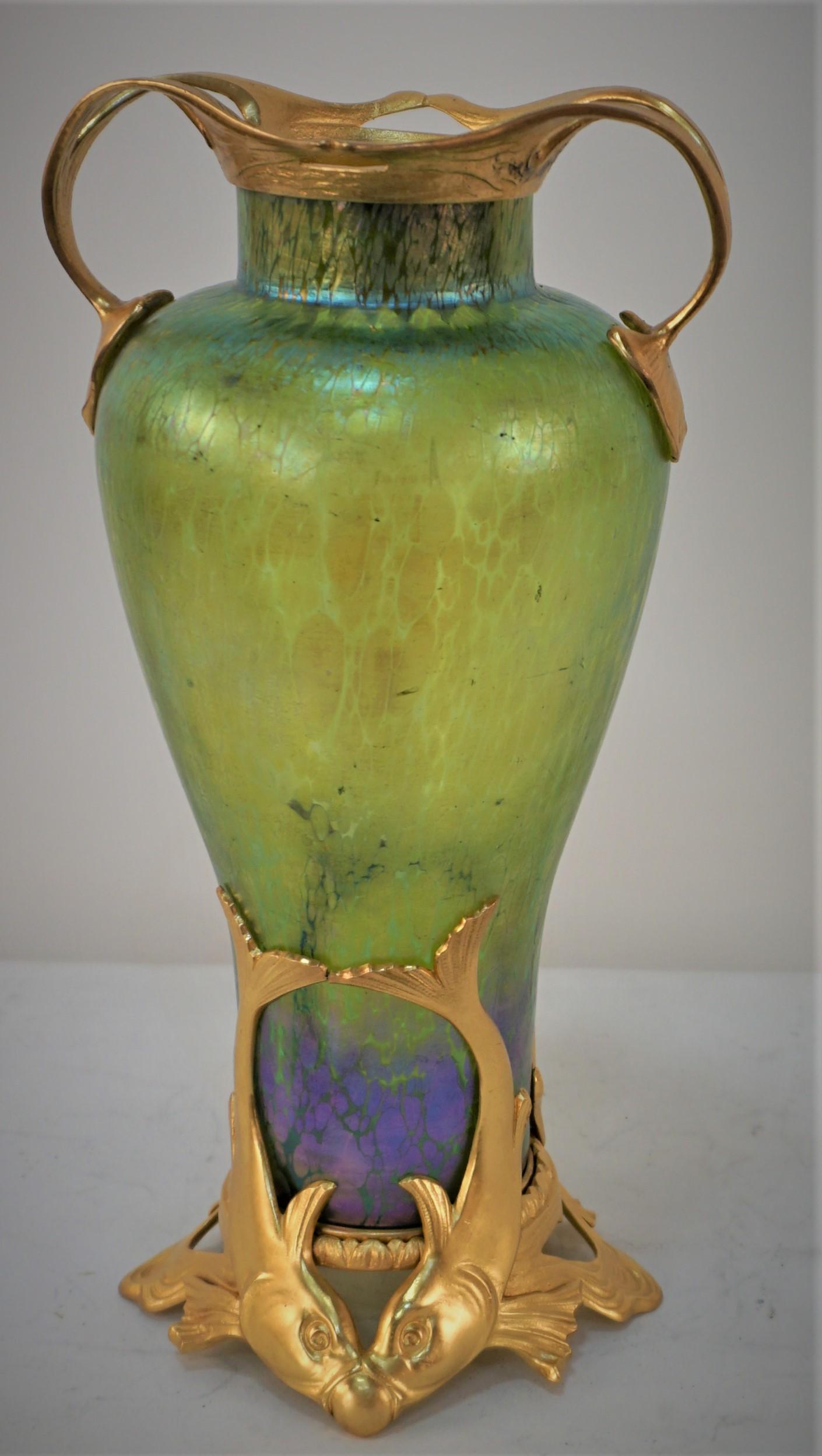 Magnifique vase en verre soufflé vert irisé avec base de dauphin en bronze doré et poignée dorée. 