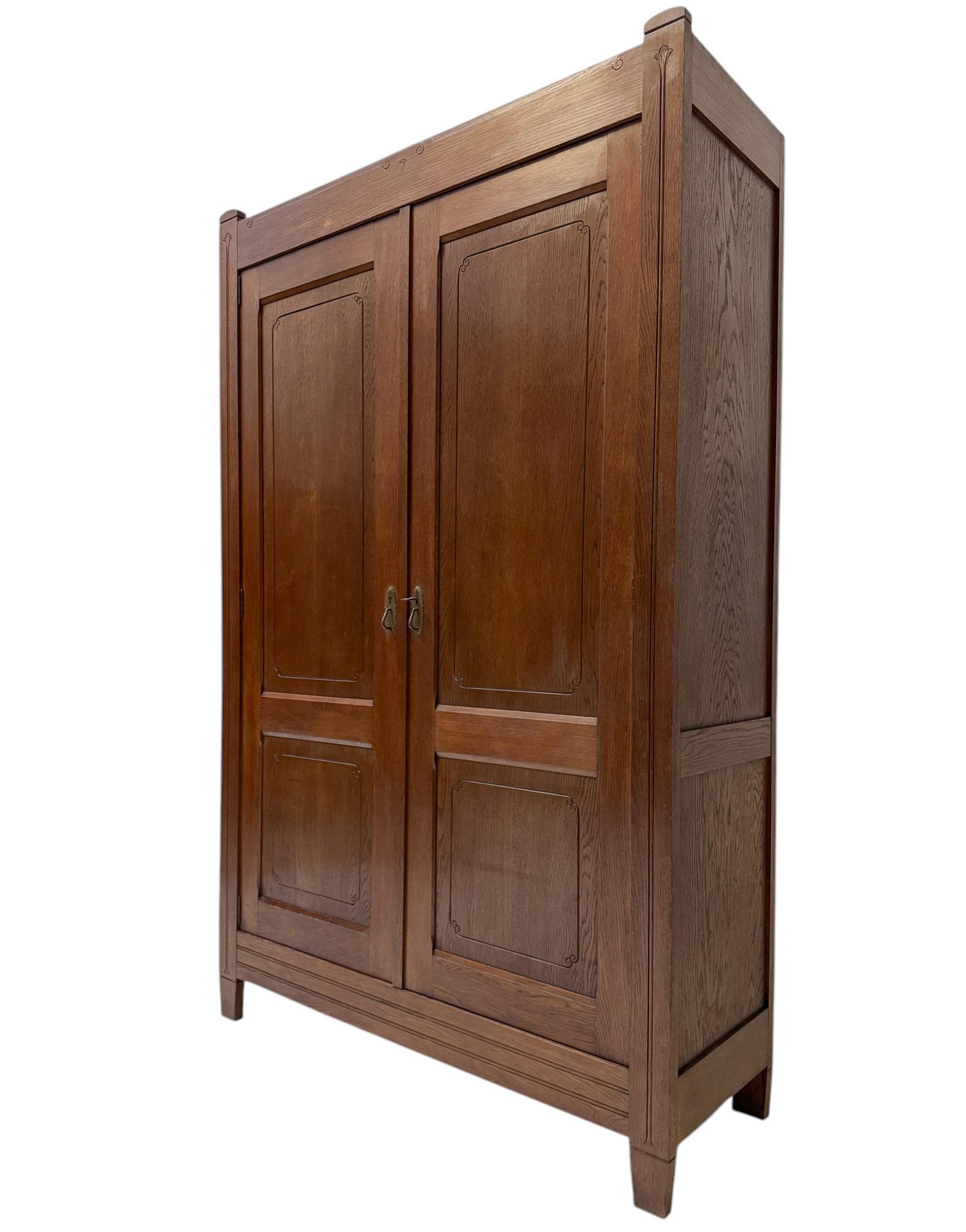 Stunning and rare Art Nouveau Arts & Crafts armoire or wardrobe.
Design by W. Gieben Amsterdam.
Striking Dutch design from the 1900s.
Solid oak  with original patinated brass handles on both doors.
Eight wooden shelves inside.
This wonderful Art