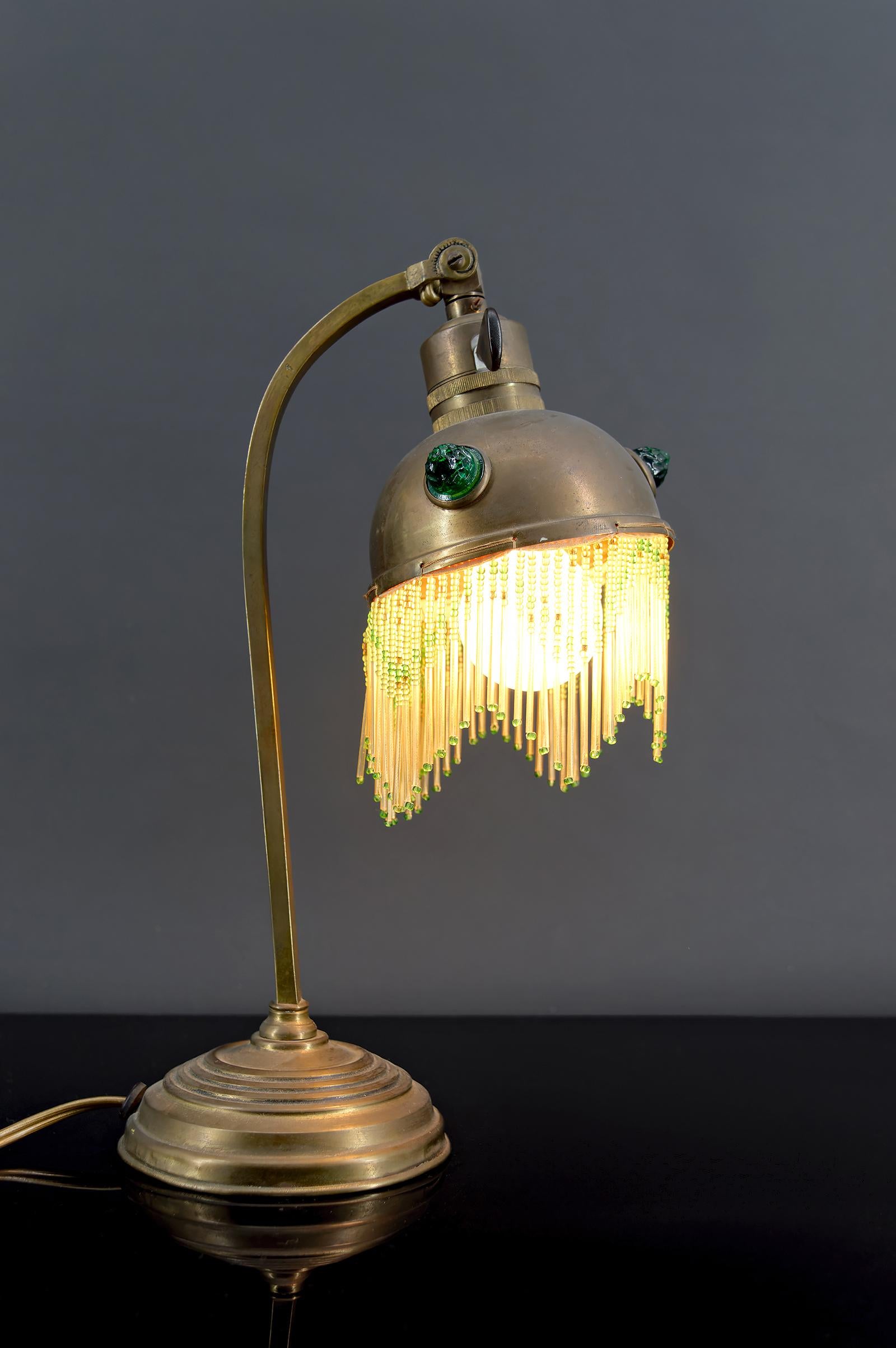 Lámpara de mesa Art Nouveau de latón con cabujones de cristal, circa 1910

Añade un toque de elegancia a tu hogar con esta impresionante lámpara de escritorio de estilo Art Nouveau. 

Fabricada en latón, presenta una pantalla delicadamente adornada