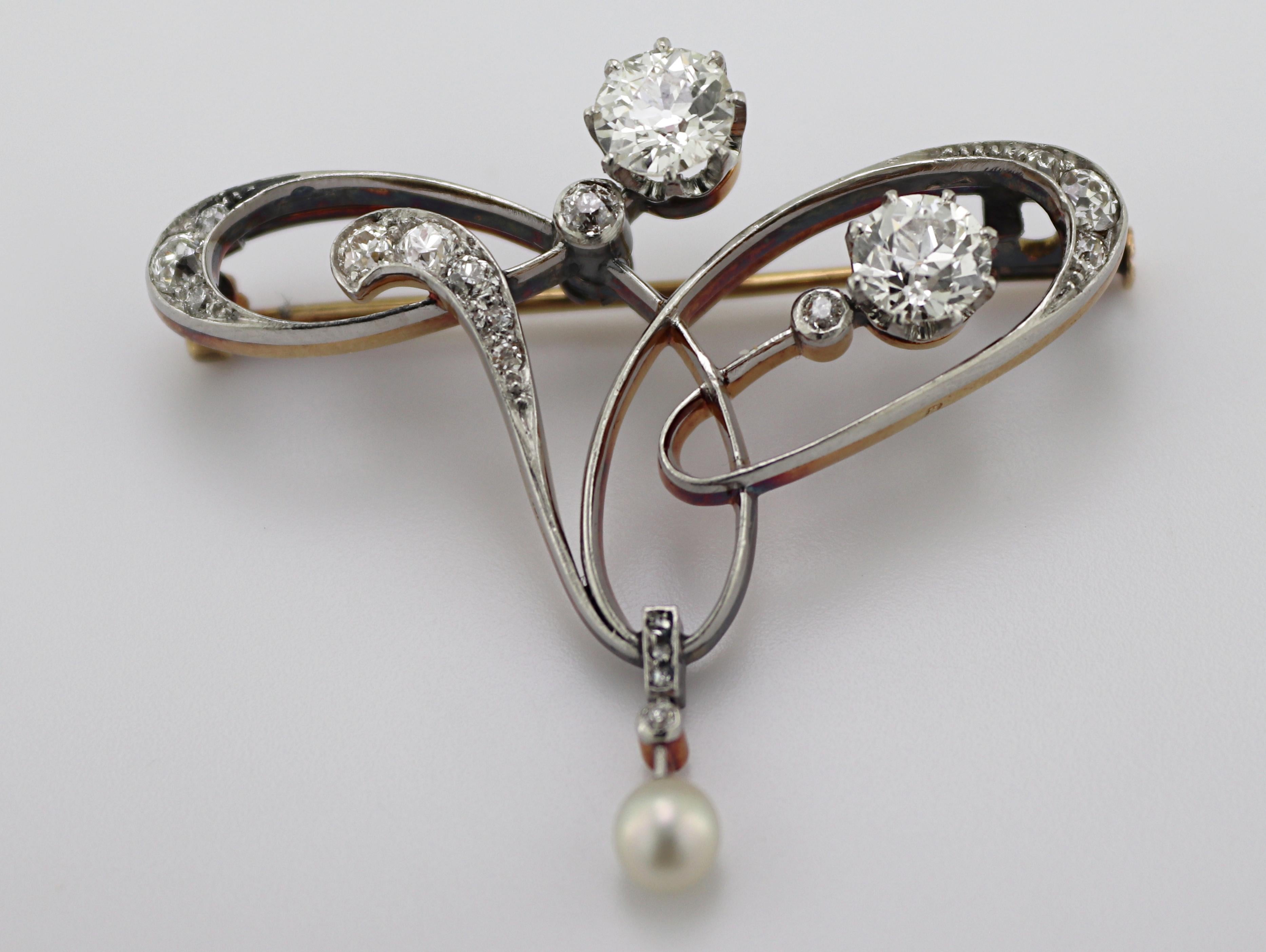 Designed with an asymmetric open scroll motif, featuring two old European-
cut diamonds, 1.15 ctw , I, J-L, accented by twenty old mine and rose -cut
diamonds, 0.35ctw , SI-I, J-K, suspending one 4 mm pearl, set in a
platinum -topped 14K yellow gold