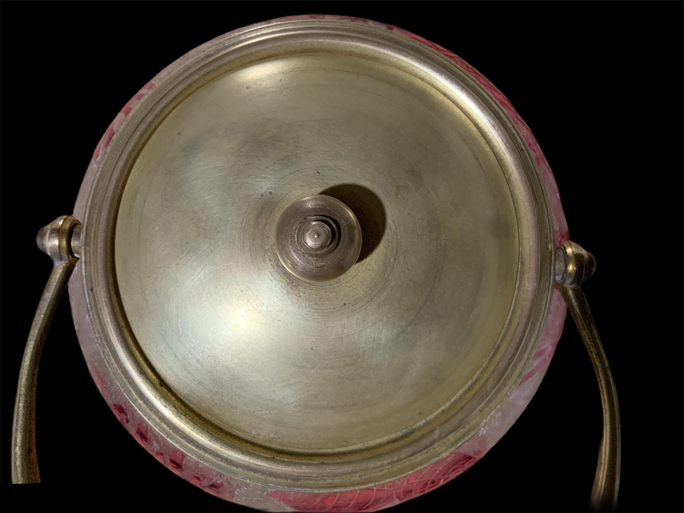 This is an Art Nouveau Baccarat crystal cookie lidded jar/bowl. It features an engraved clear crystal background with multiple fern leaves decorated with a continuous pink honeysuckle flowers and leaves creeps. The rim is bordered with gold plated