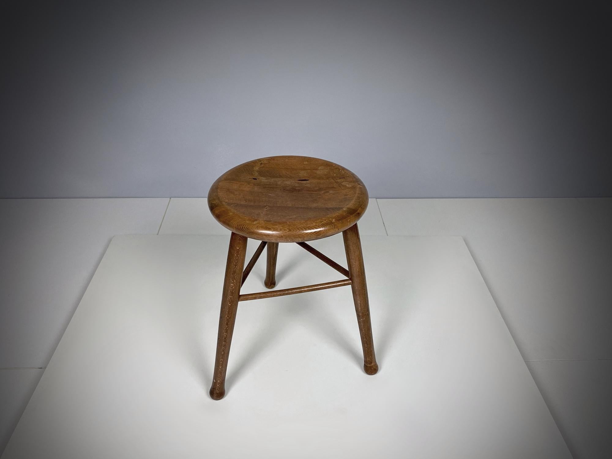 A beautifully simple three-legged oak stool handmade in 1910s, Vienna, Austria. The stool have nice crafted details such as the ball shaped legs, the cross construction and the nicely carved seatings. The solid oak shows an incredible patina. In