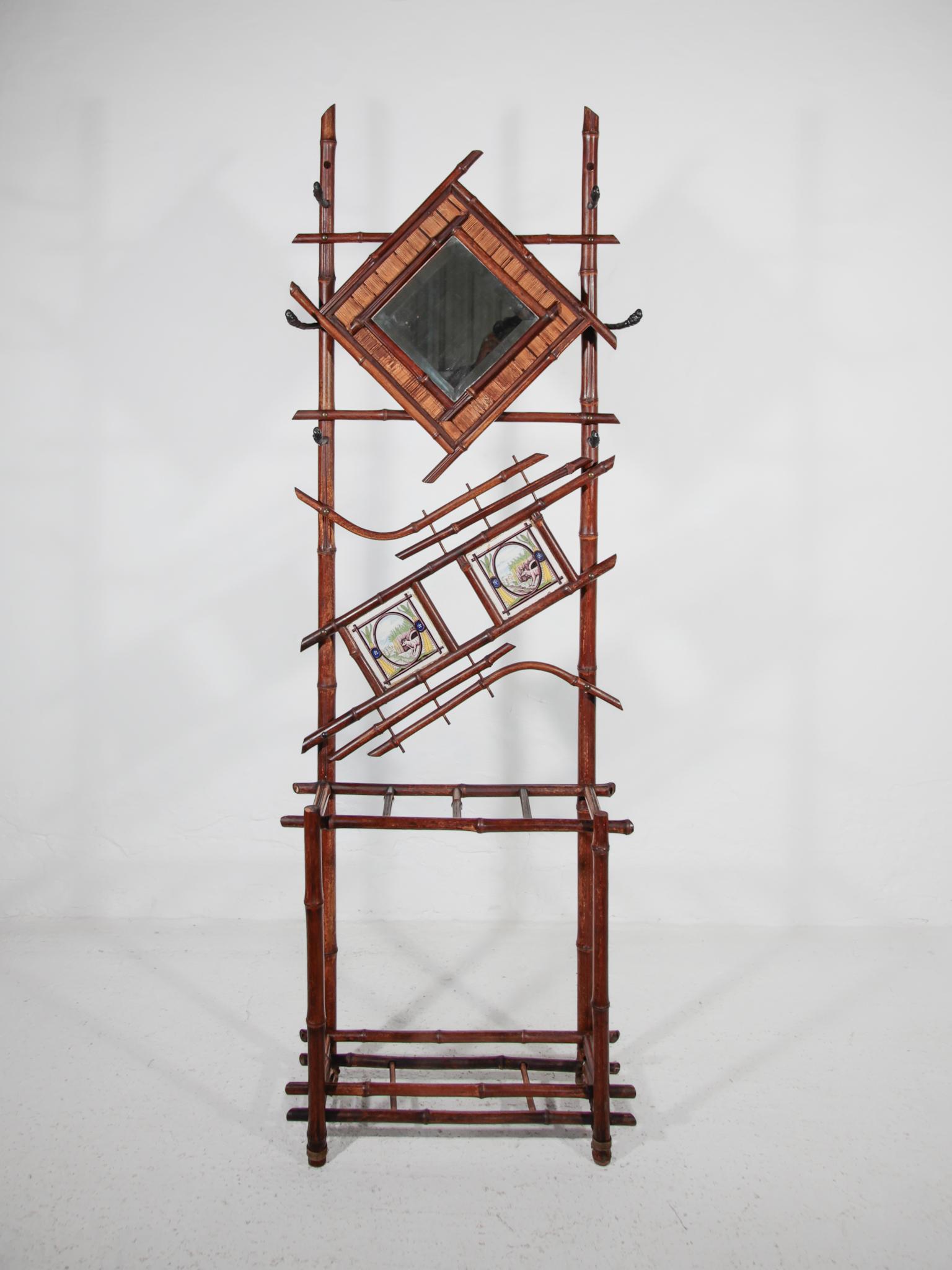 Appendiabiti da sala e portaombrelli in bambù Antique French Art Nouveau. Appendiabiti originale francese in bambù con specchio e sei ganci per cappotti e cappelli, decorato con due antiche maioliche del XIX secolo dipinte a mano con cani in un