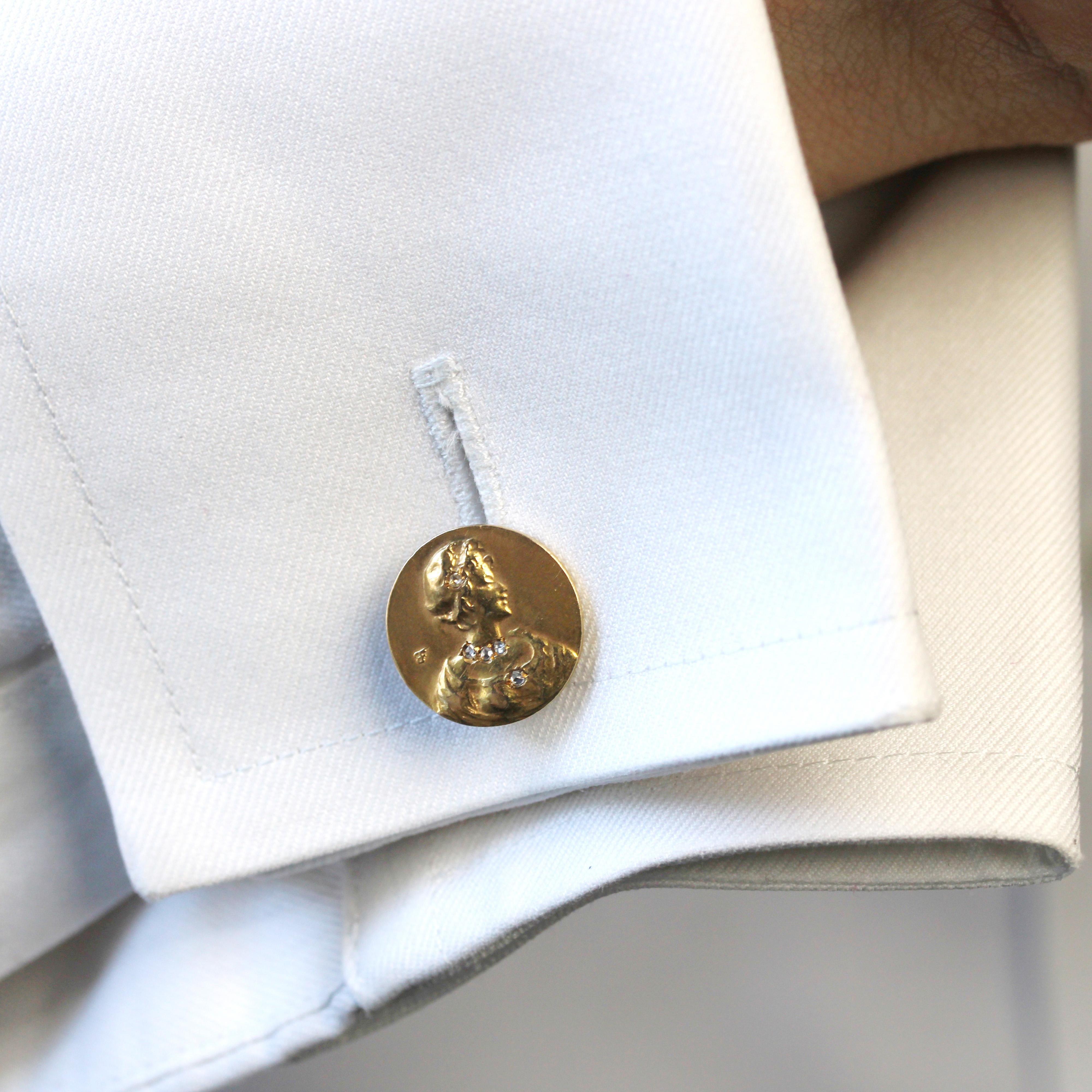 Cufflinks in 18 karat yellow gold.
Round in shape, these antique cufflinks are each adorned with a bust of a woman whose headdress, neck and dress are set with rose-cut diamonds. The fastener is a jaseron chain with bombshells at the end. One of