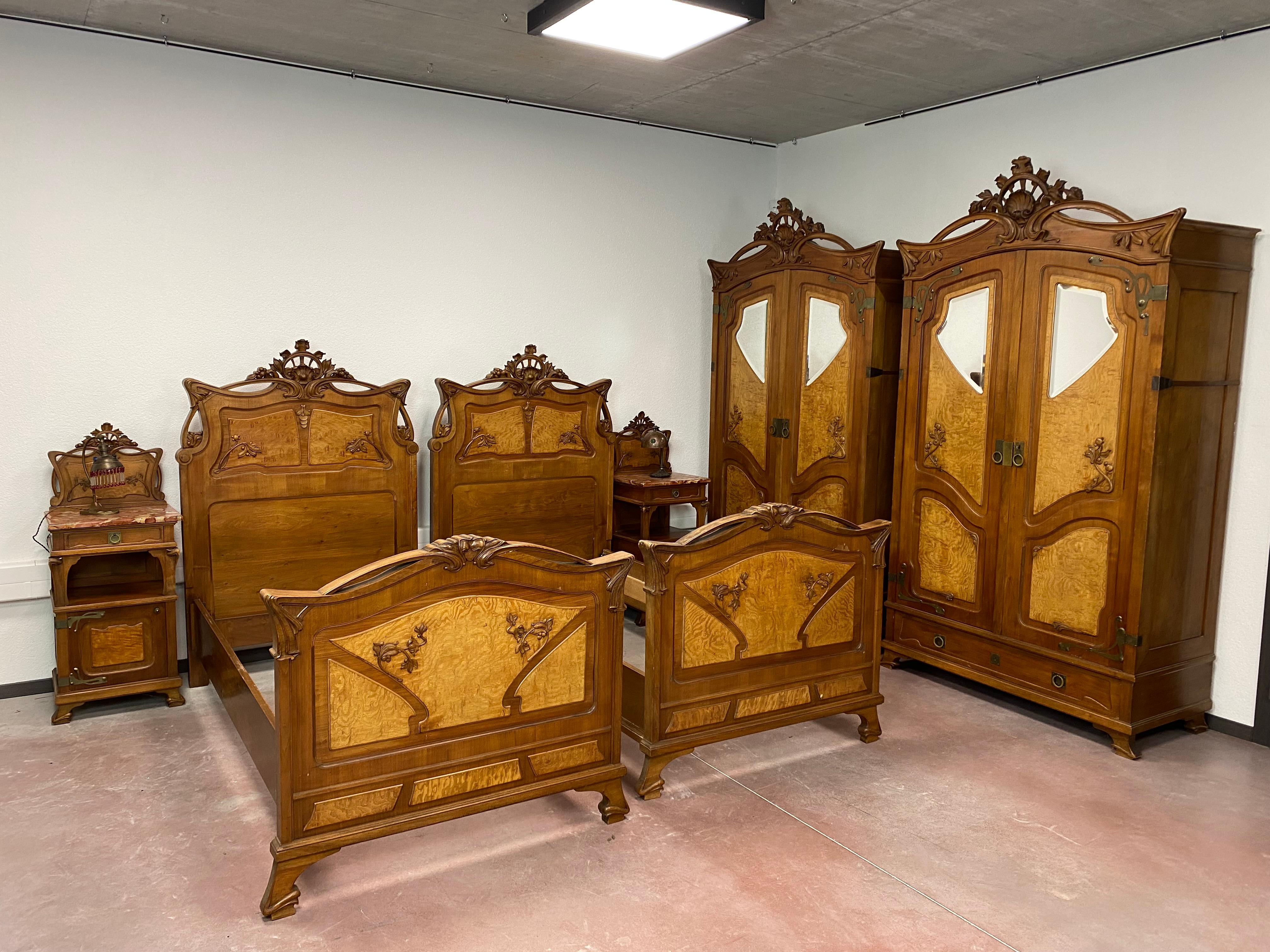 Jugendstil-Schlafzimmergarnitur nach Louis Majorelle um 1900, Kombination aus Holz und Messing.

Abmessungen:
2xBett 200x104cm
2xNachttisch 47x38x116cm
2xKleiderschrank 122x55x230cm
Spiegel