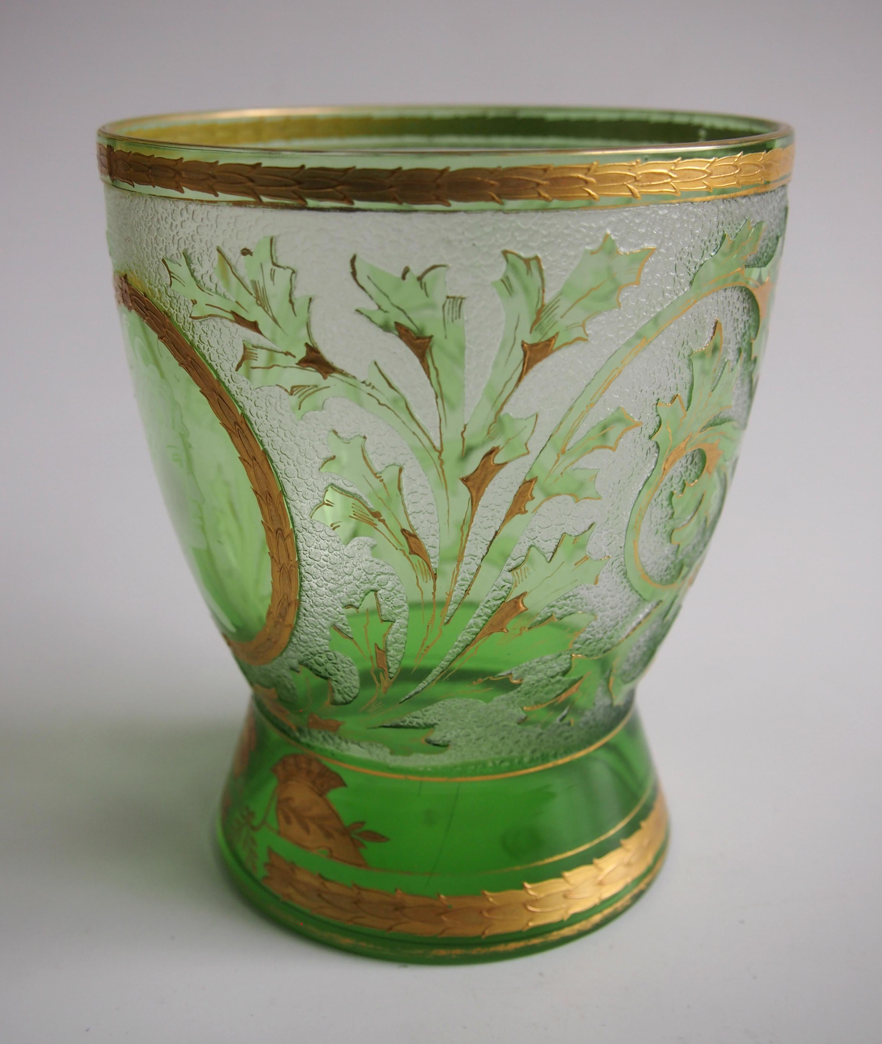 Superbe vase Riedel en camée et doré, vert sur transparent - 'Helmet'. Le corps principal est décoré de feuilles et de branches vertes soulignées par des dorures. Il présente un visage de profil blanc très fin d'une dame dans un cartouche d'or. Il