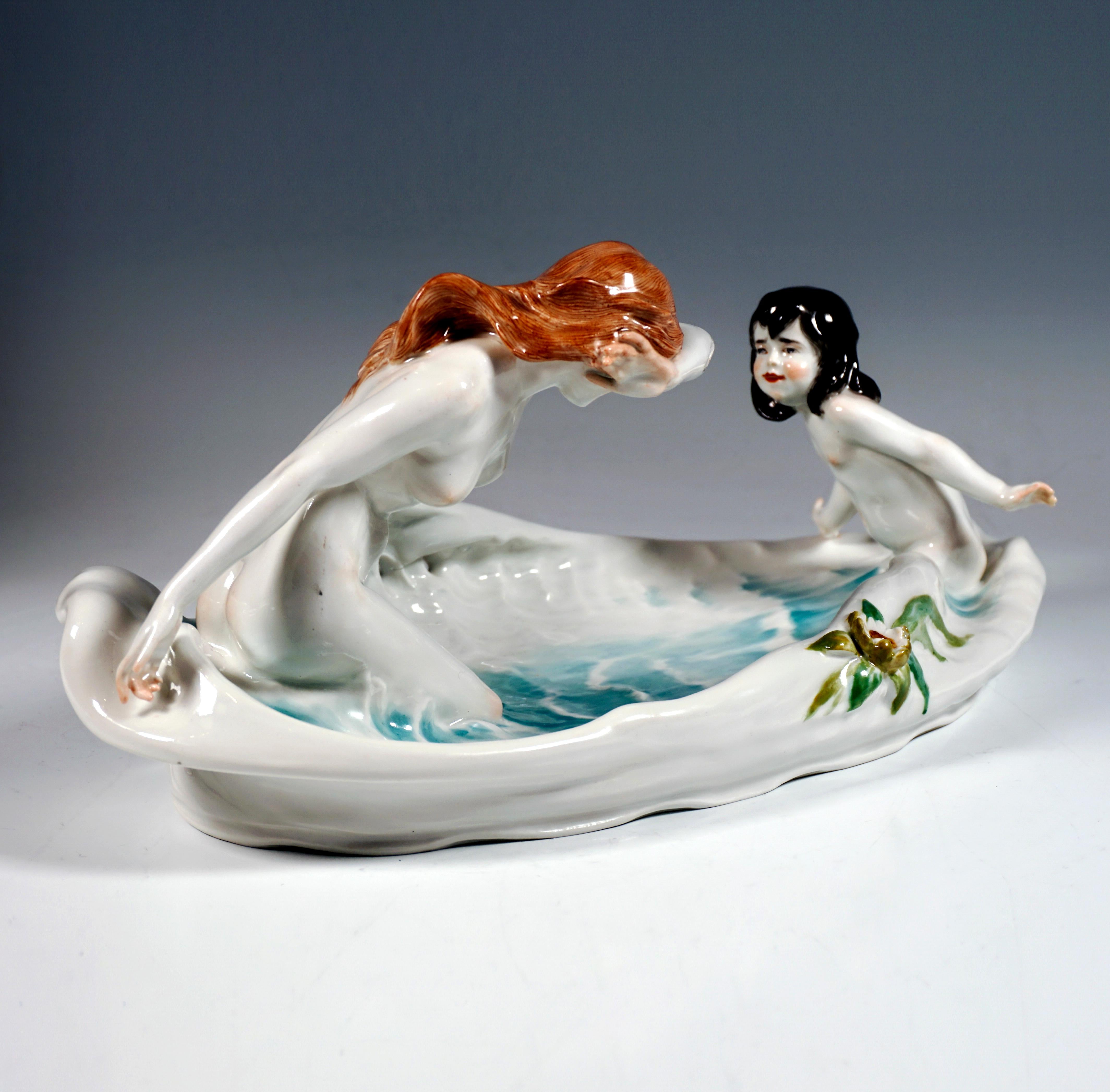Exquisite Meissen Art Nouveau porcelain group:
Flat oval bowl with an irregular, wavy lined and partially pierced rim, on the narrow sides two naked figures facing each other, a young girl and a young woman with long hair playing in the waist-deep,