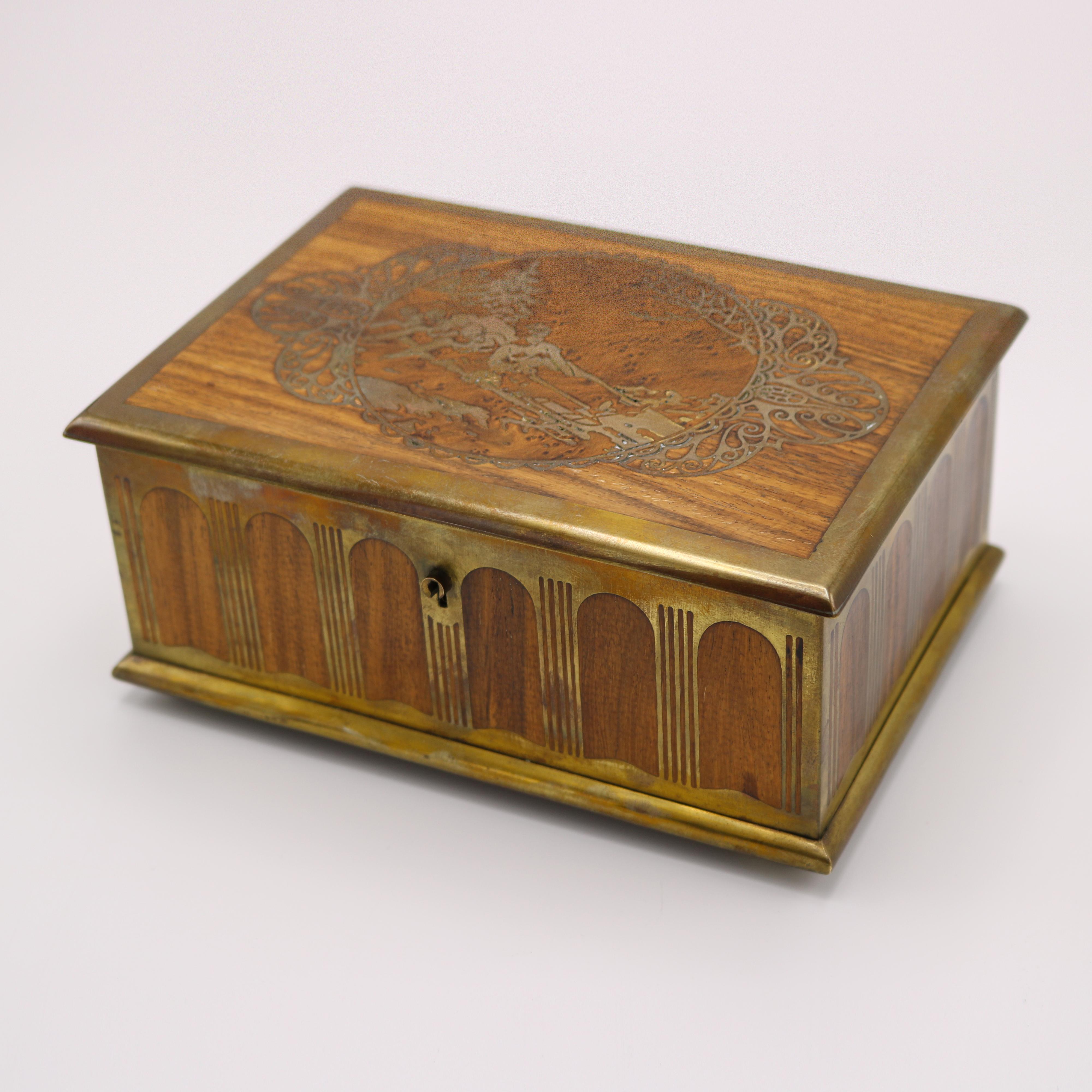 Caja rectangular Art Nouveau con motivo de trineo Diseñada y fabricada por Erhard & Söhne. Burlwood, y latón. La incrustación de latón de la parte superior representa un trineo con una tripulación de cuatro hombres en la nieve.