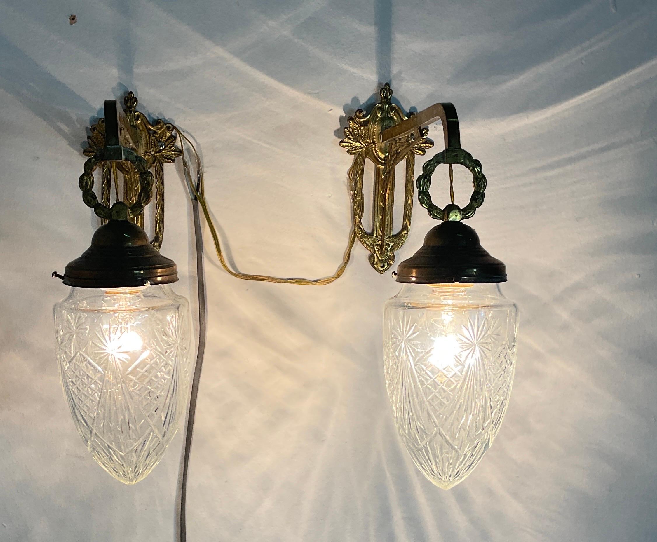 1950s Art Nouveau brass wall lamp with glass bowls at the end. Applique in good condition with small wear caused by use and the passing of years. The characteristics of this style consist of motifs inspired directly by the truth, especially by the