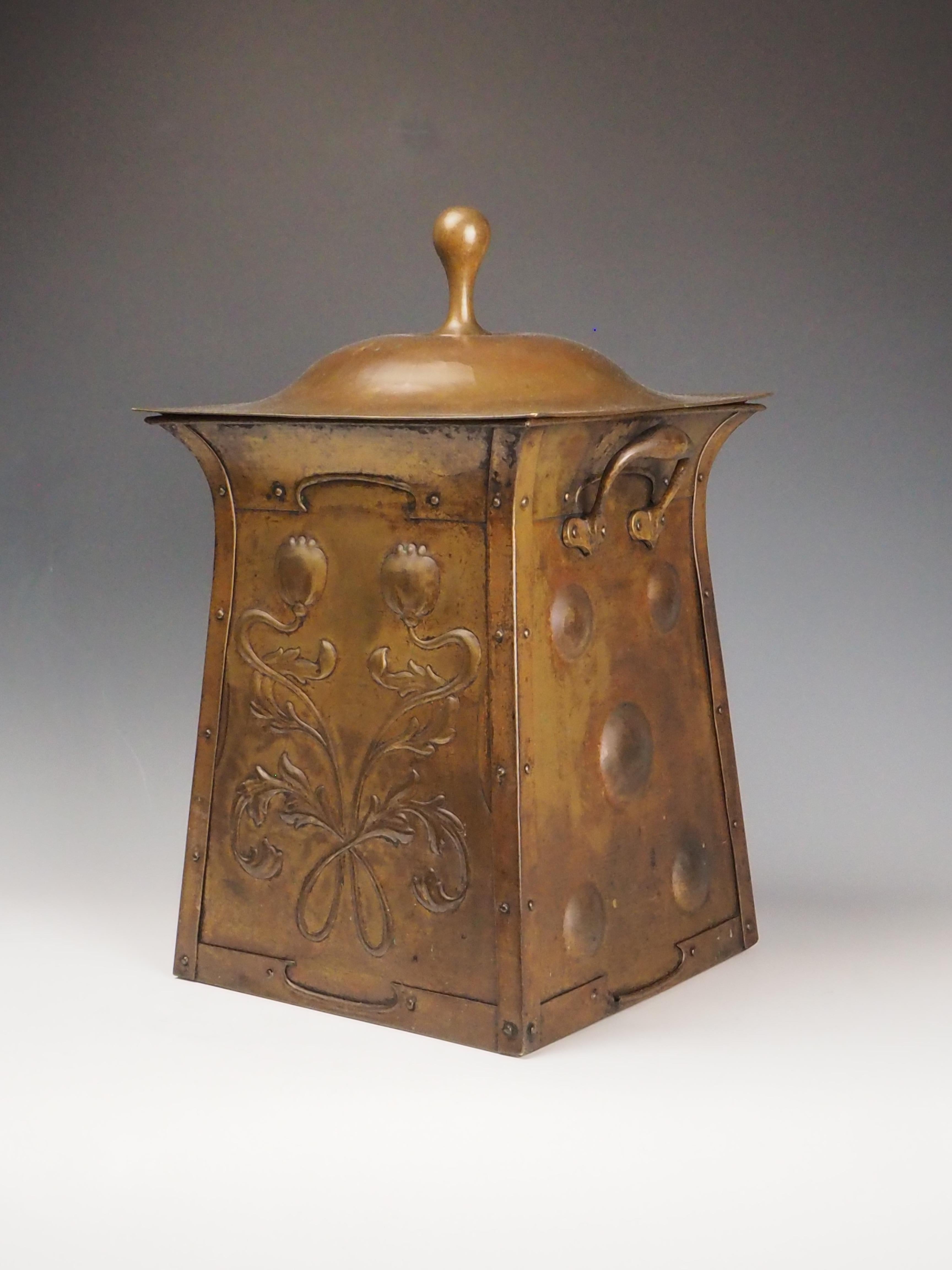Art Nouveau Brass Fireside Coal Scuttle, Late 19th Century
A decorative brass coal scuttle from the late 1800s, featuring a tapering form adorned with hammered heart-shaped (cordiform) and flowing foliate motifs, characteristic of the Art Nouveau