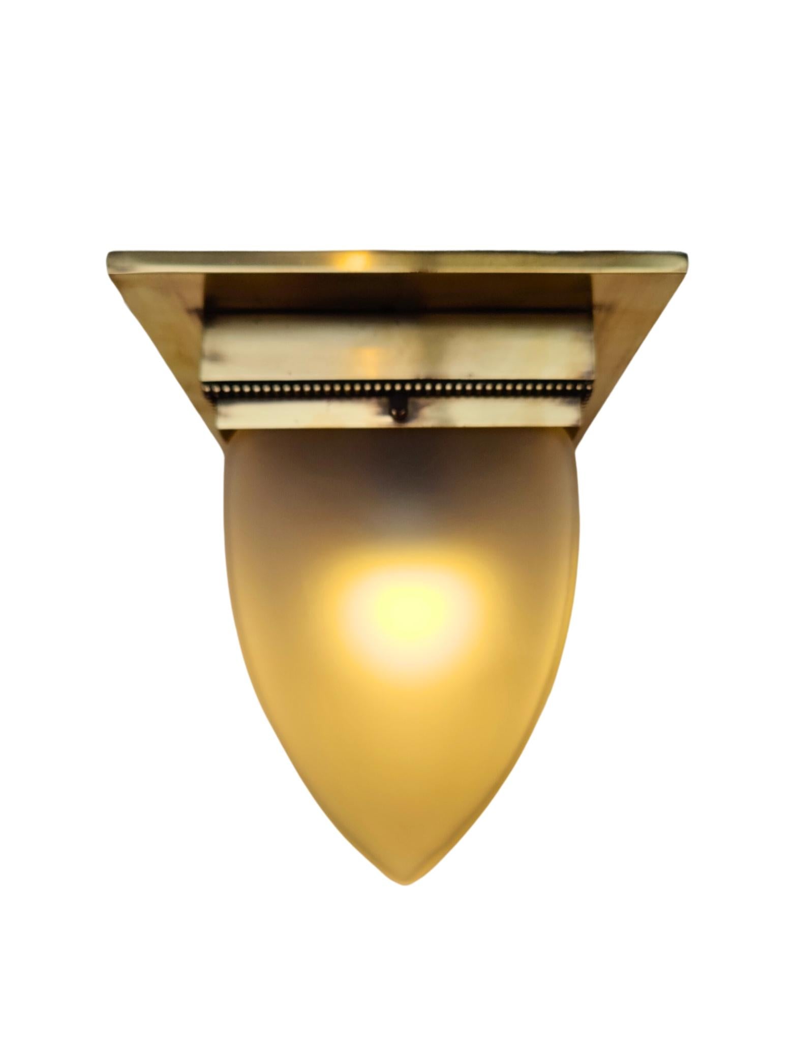 This authentic Art Nouveau ceiling light from around 1910 features a finely crafted solid brass mount with decorative beaded trim and a sculptural frosted glass shade shaped like a stylized leaf or flame. The design reflects the organic elegance and