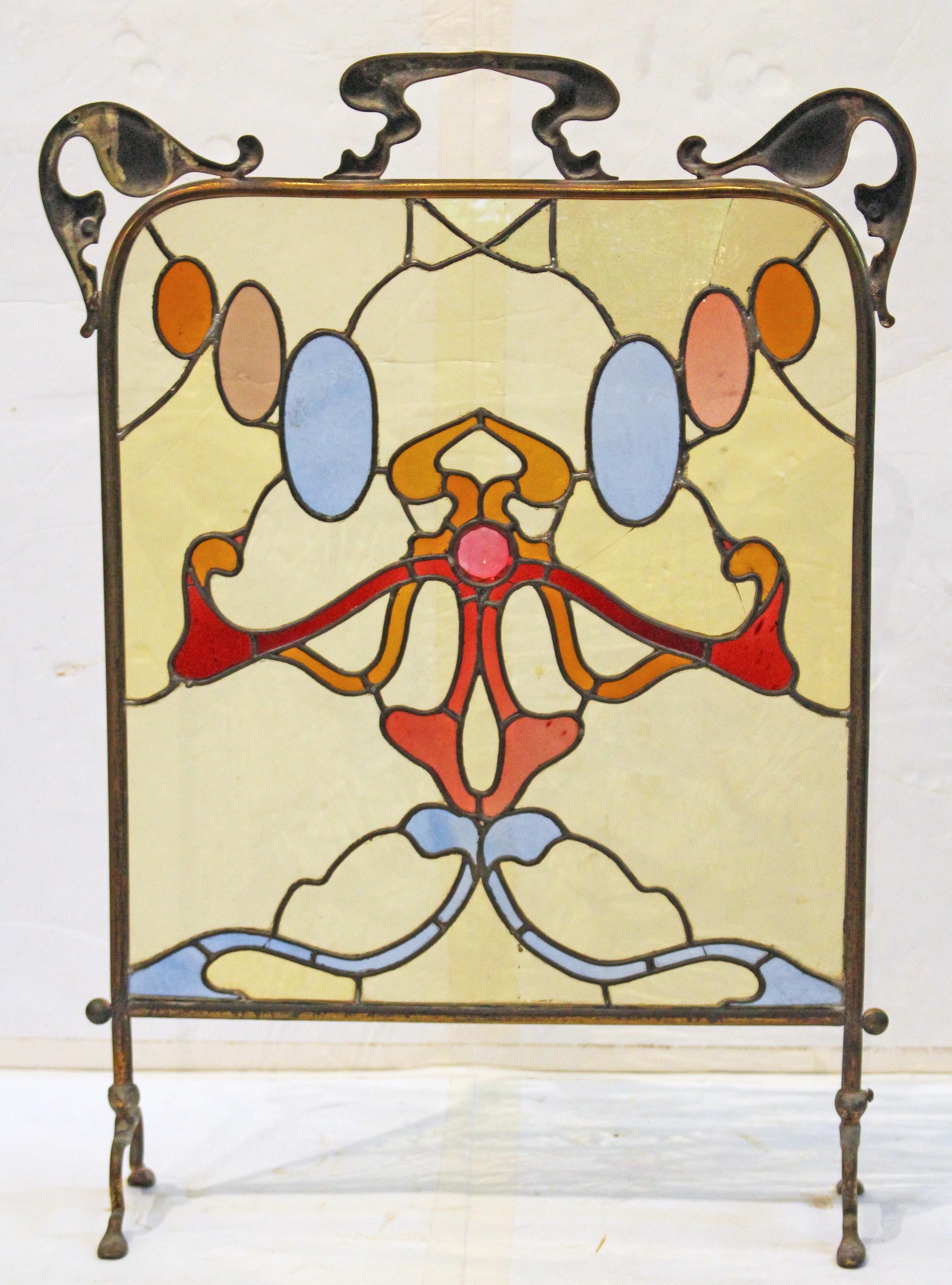 Circa 1890-1905 Pare-feu Art Nouveau en laiton et vitrail, Anglo-Américain. Des motifs art nouveau d'une grande fluidité dans le support et le panneau de verre d'origine. Trois lignes de fissures dans le verre transparent. 27 1/8