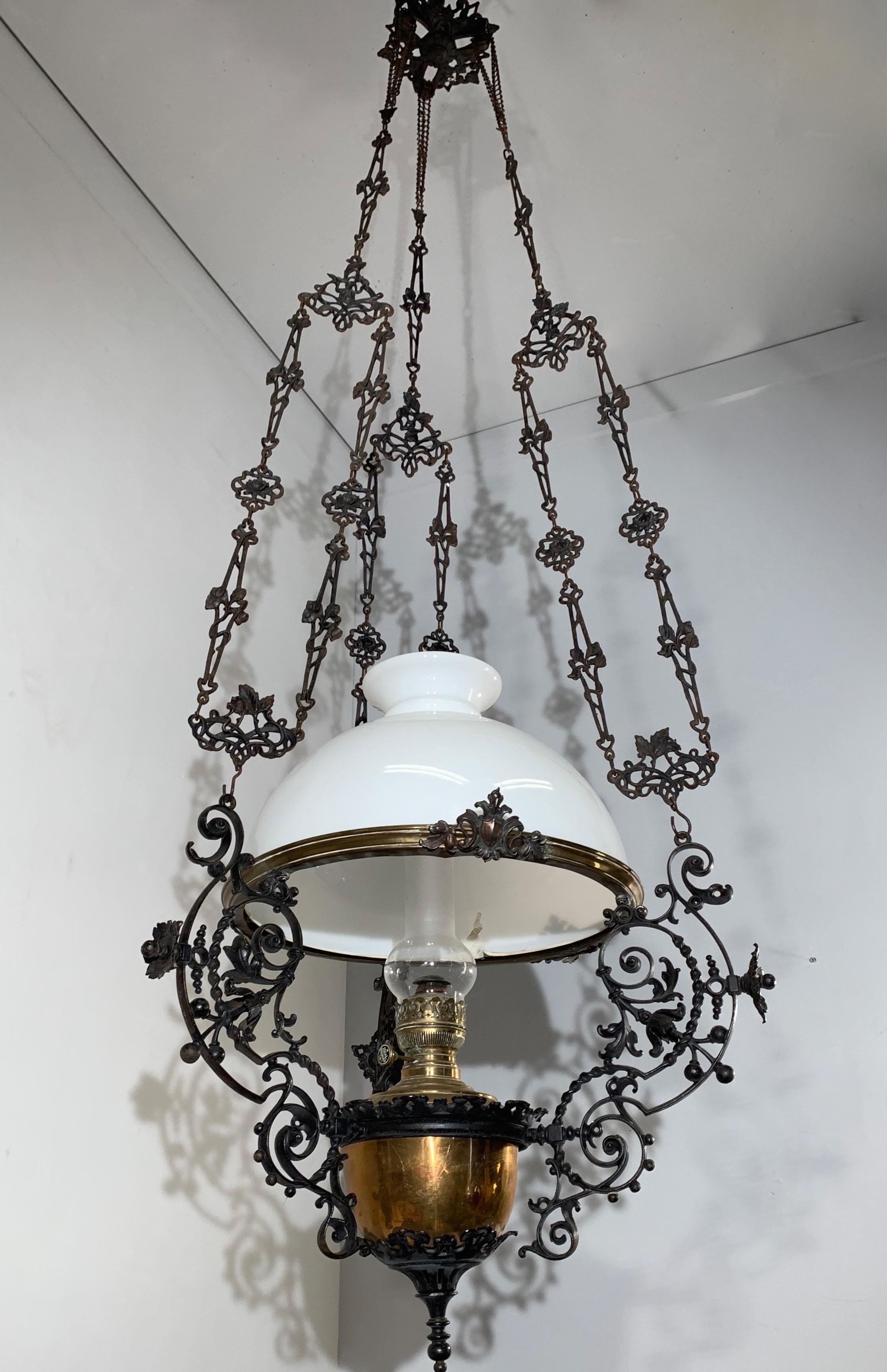 Rare and large antique oil lamp with blackened iron frame.

This large and impressive oil lamp dates from the early 1900s. It is made of different, quality materials and expensive techniques which is one of the reasons why this handcrafted antique