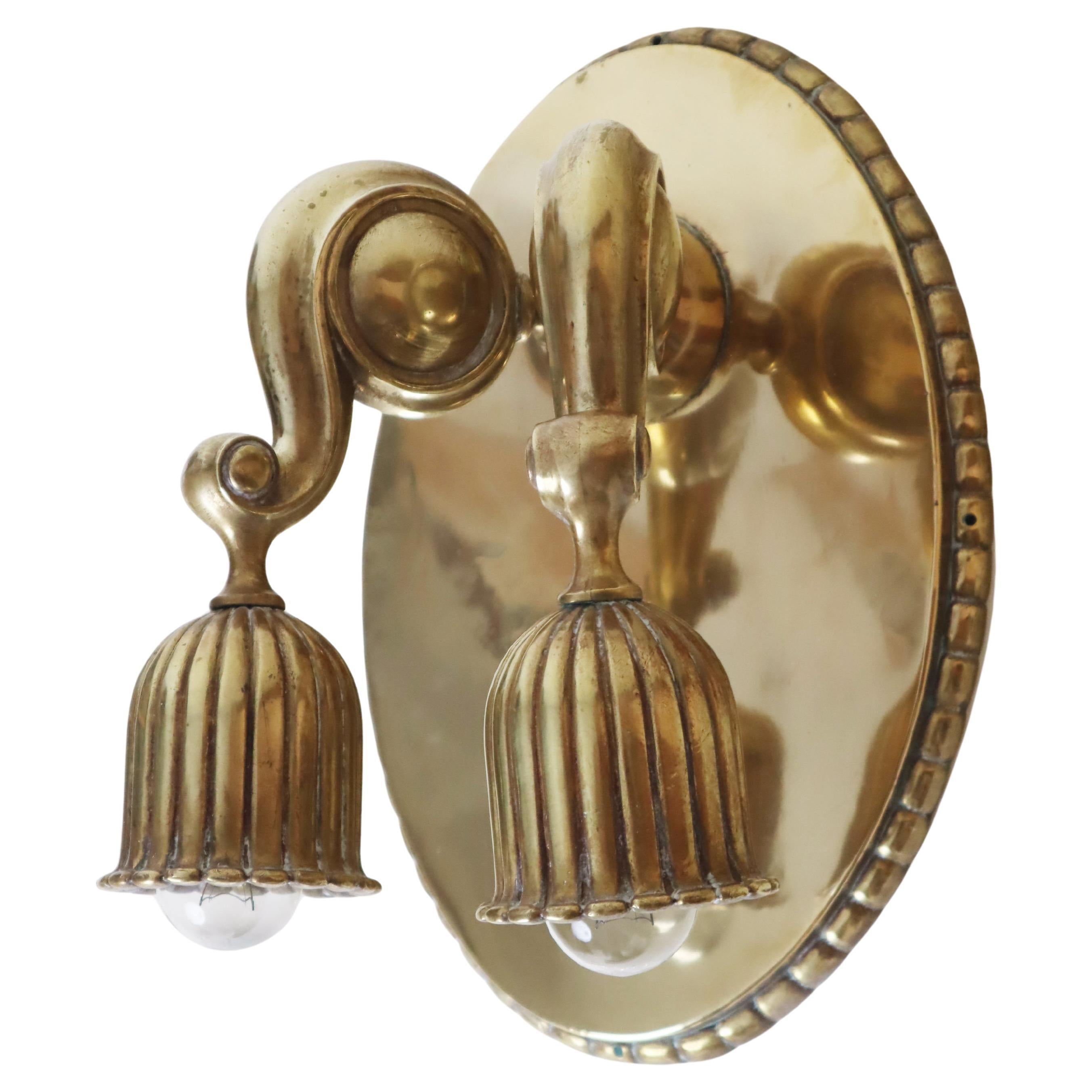This luxurious Austrian wall light is of high quality, with a solid construction, and it weighs 3.6 kg. Its timeless and elegant design reveals the handiwork of a true master of this era. The polished brass plate beautifully reflects the light from