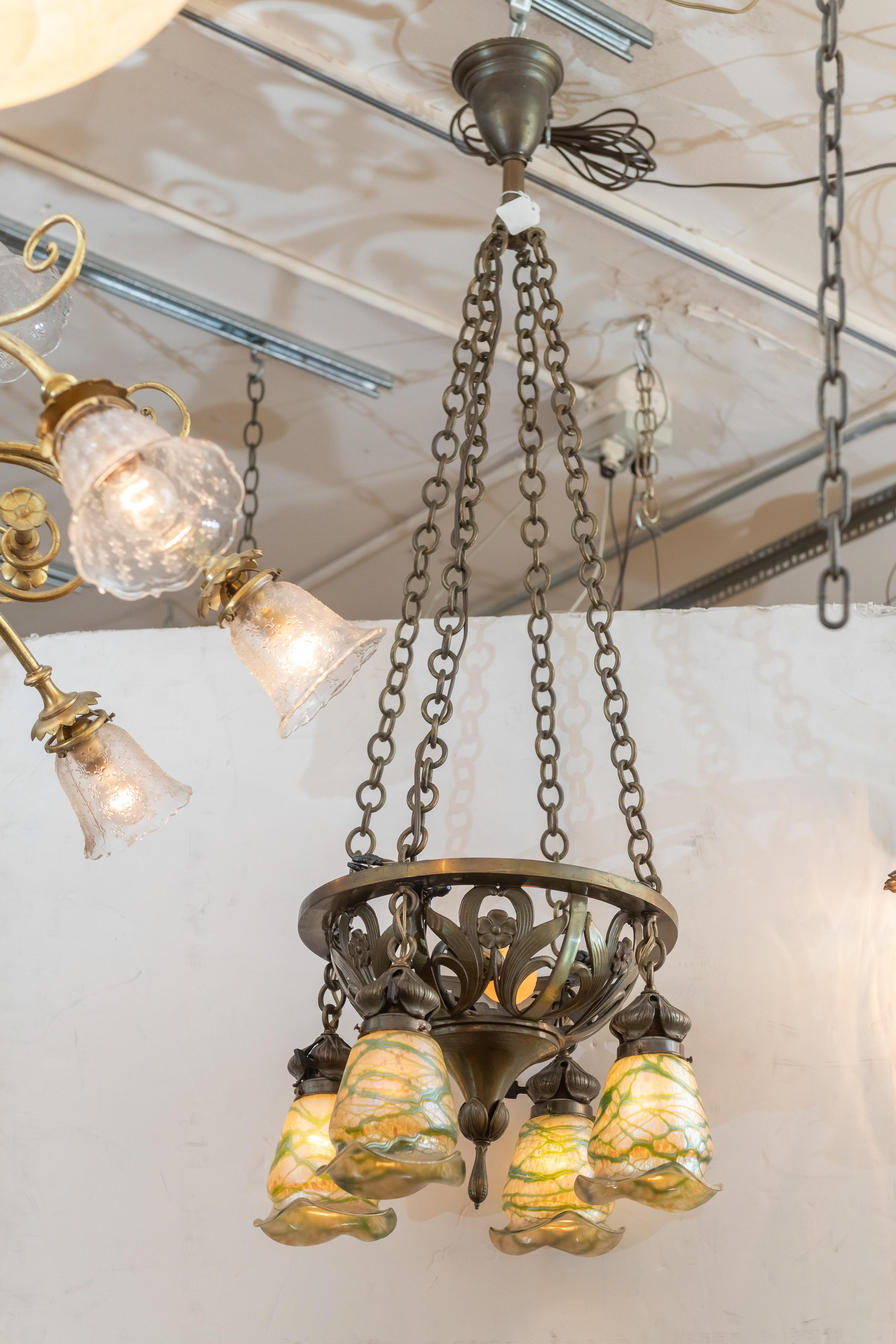 We are always on the lookout for quality art nouveau period lighting. We got a good one here. Sinewy lines and a center floral design highlight the chandelier. Now for the shades. Wow! is the best description. While the chandelier is American, the