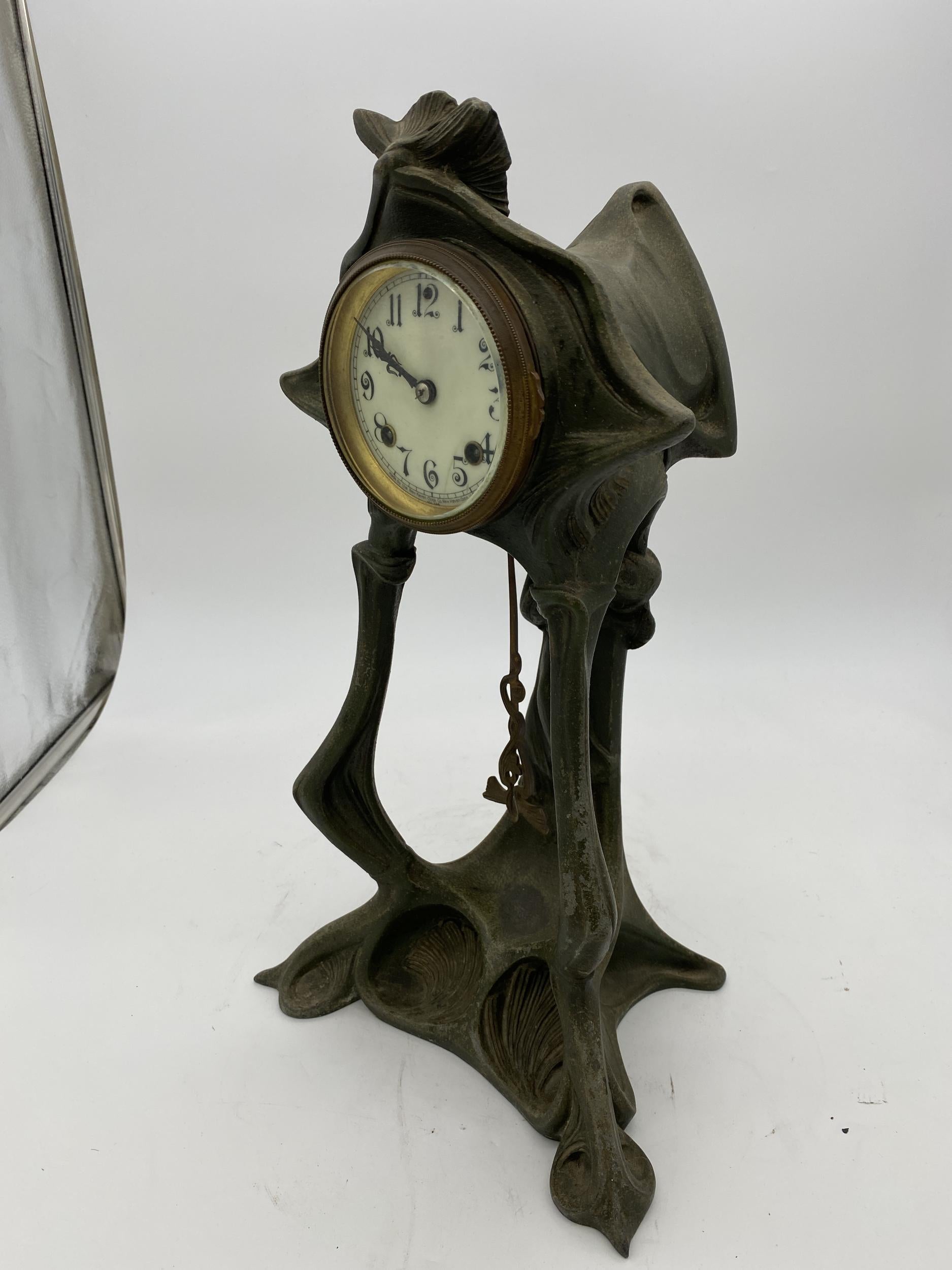 Art Nouveau boudoir clock by New Haven Clock Co. features iron cast foliate and floral form frame, porcelain face with Arabic numbers and protected by bevelled crystal, in working condition and with key, early 20th century.

Measures: 12
