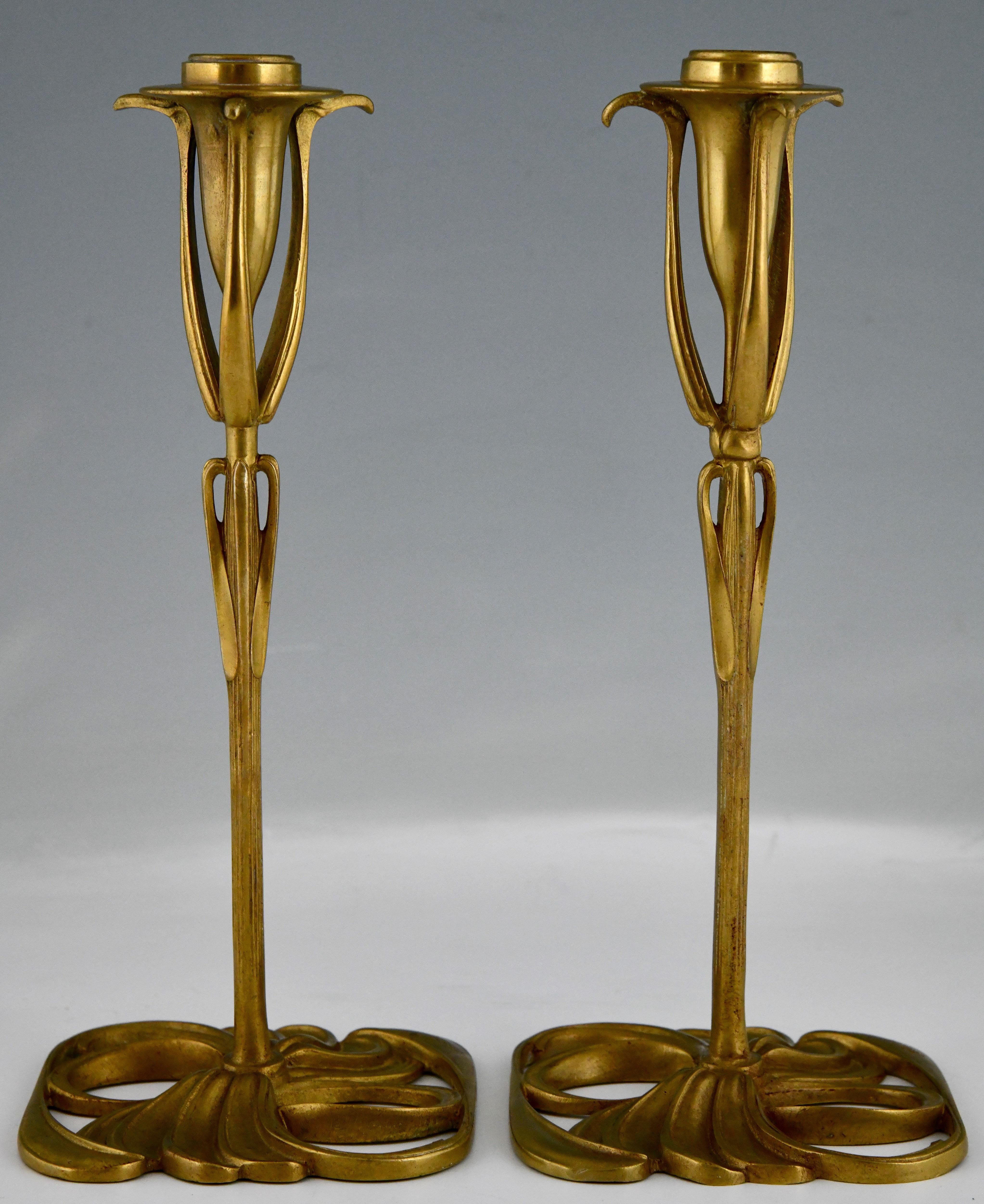 Art Nouveau bronze candlesticks with floral design by Georges de Feure. 
Patinated bronze, France 1900. 
These candlesticks are illustrated in: Lampen und Leuchter, Art Nouveau Art Deco, Wolf Uecker, Schuler. 